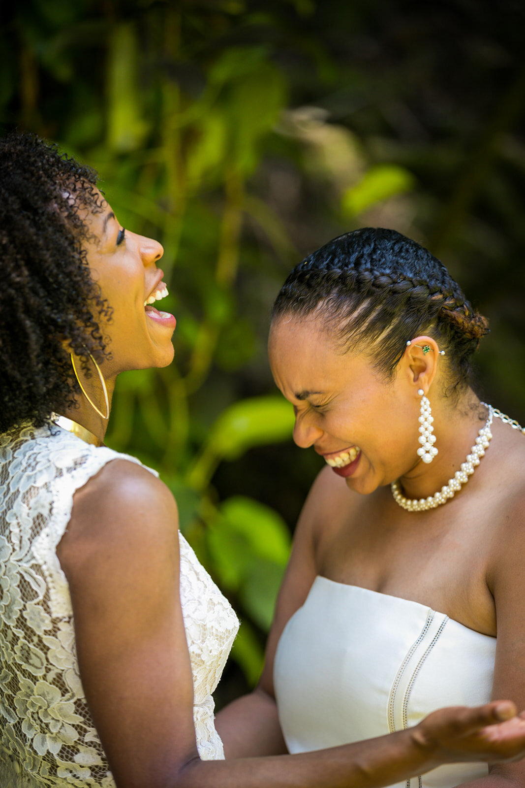 LGBTQ+ wedding with two African American brides exchanging vows at the Falls at Reeds Island in Hilo, Hawaii.