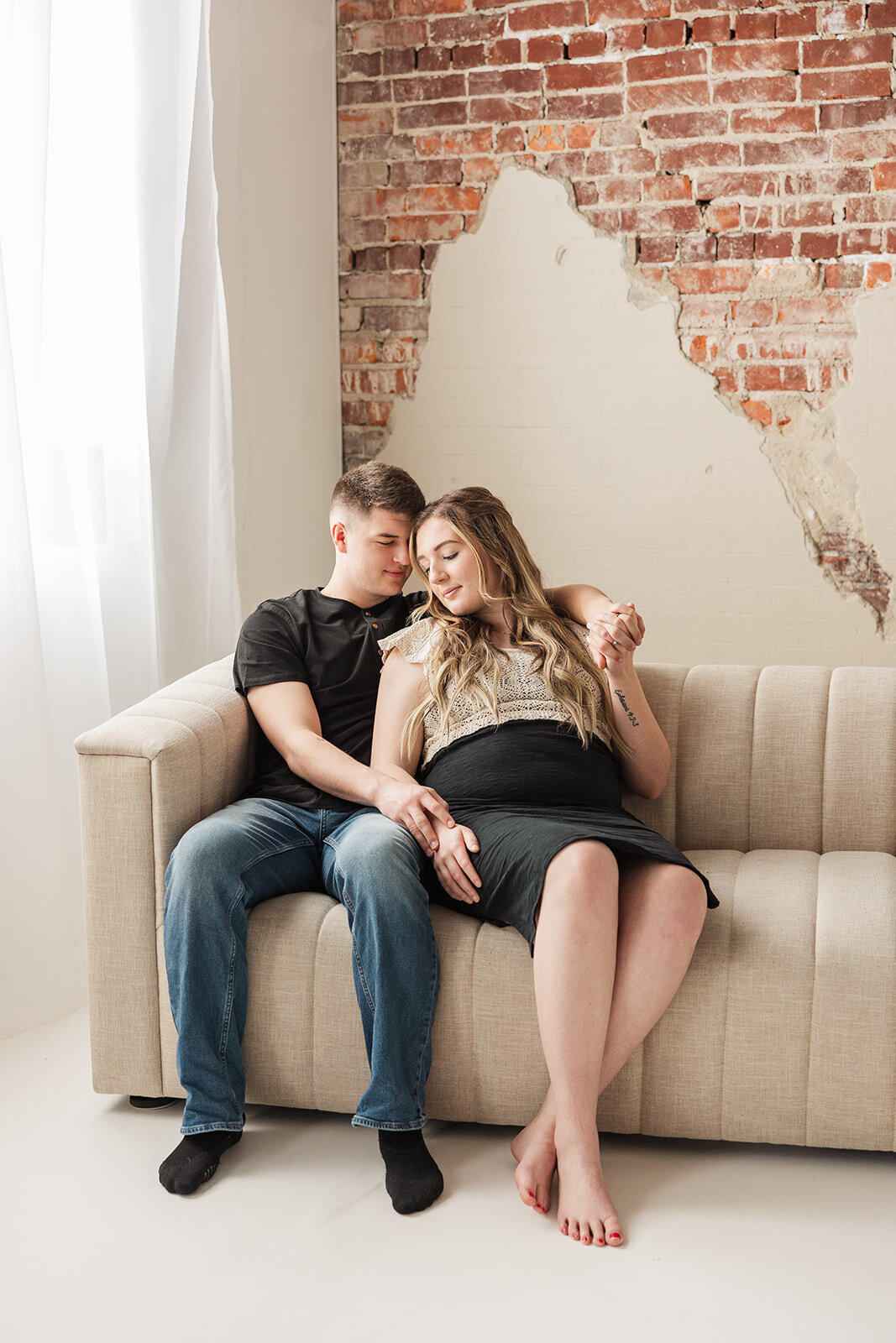 Pregnant couple sitting on the couch