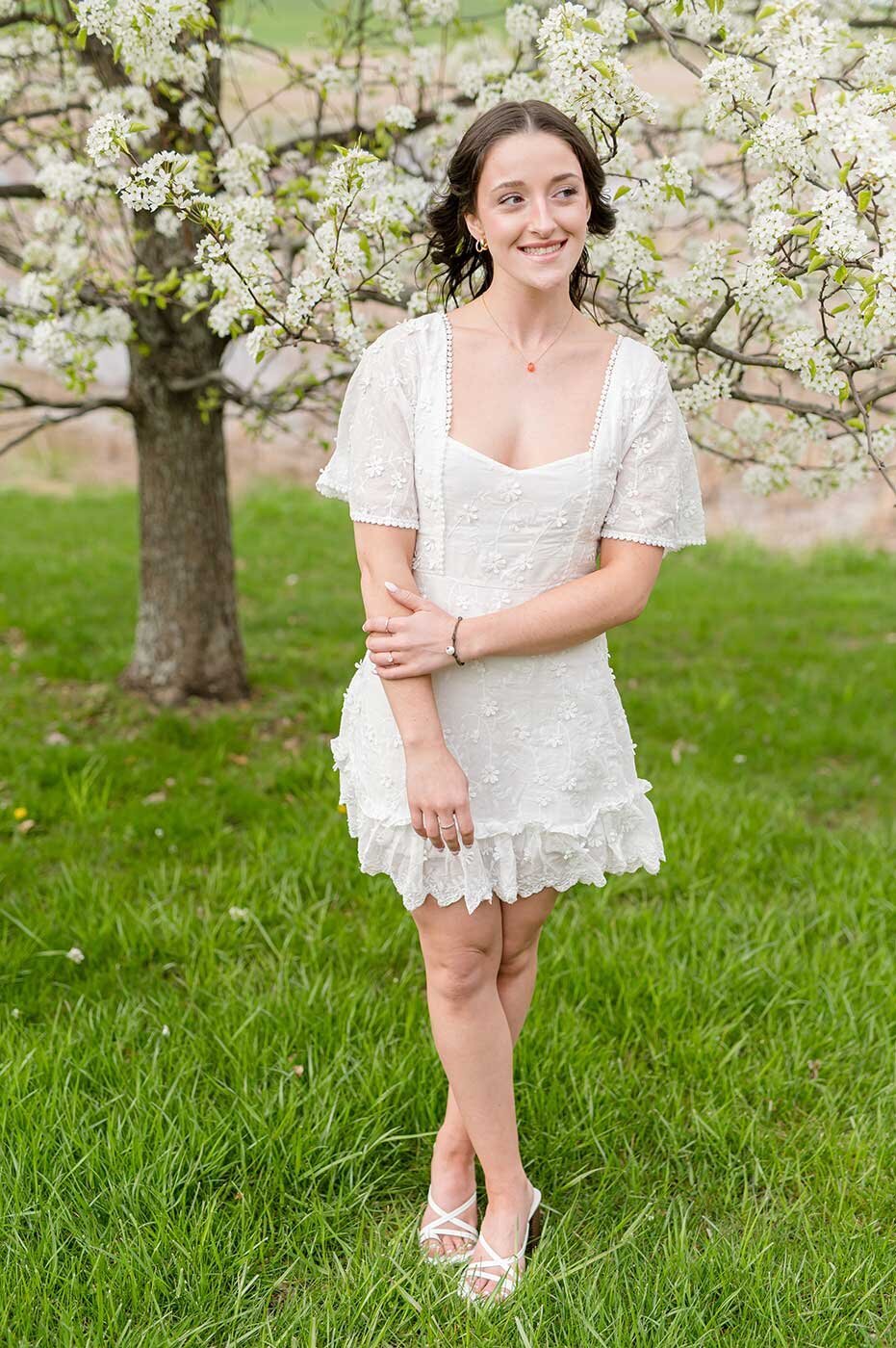 Girl standing near flowering tree on college campus