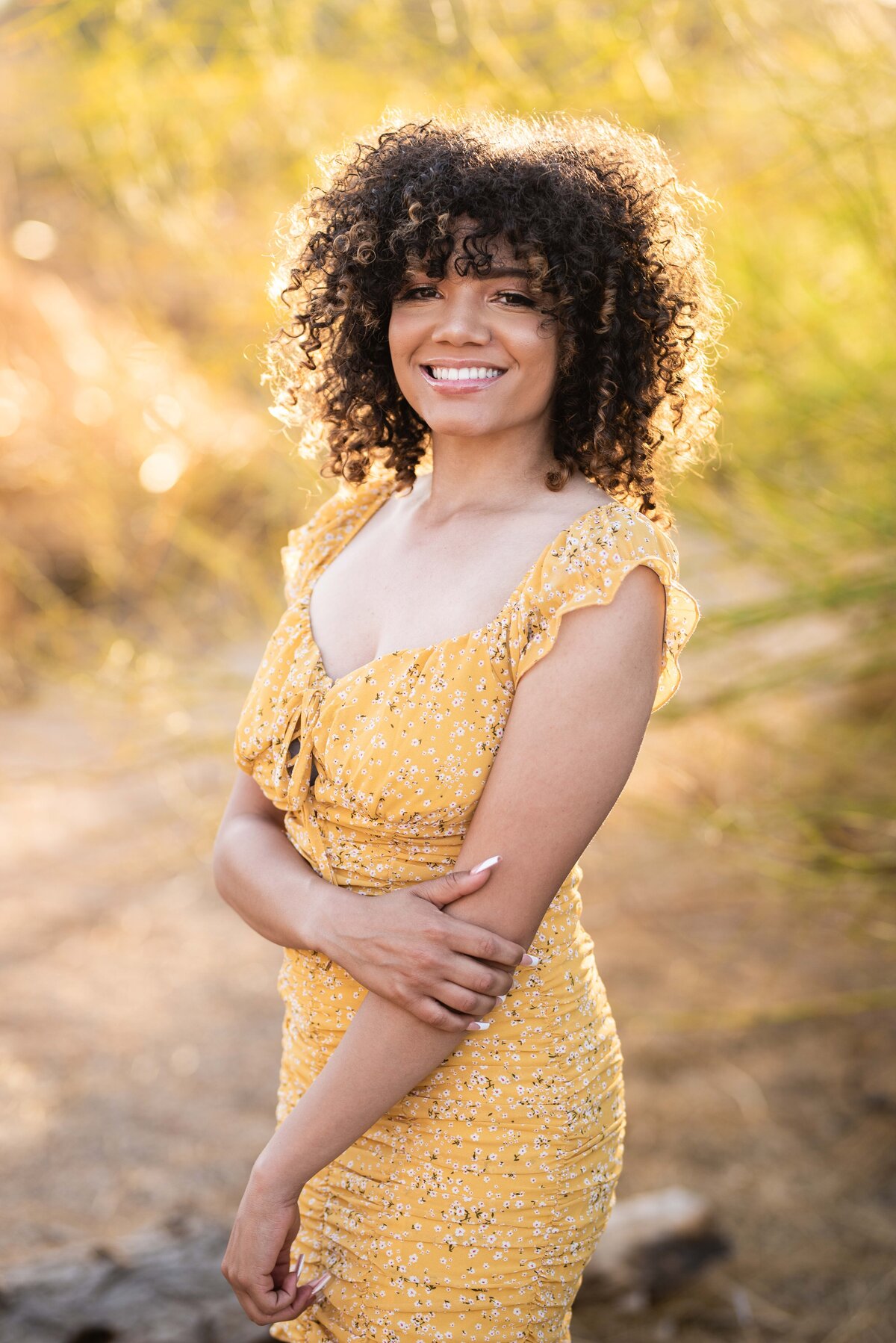 Senior girl with big curly hair and yellow dress