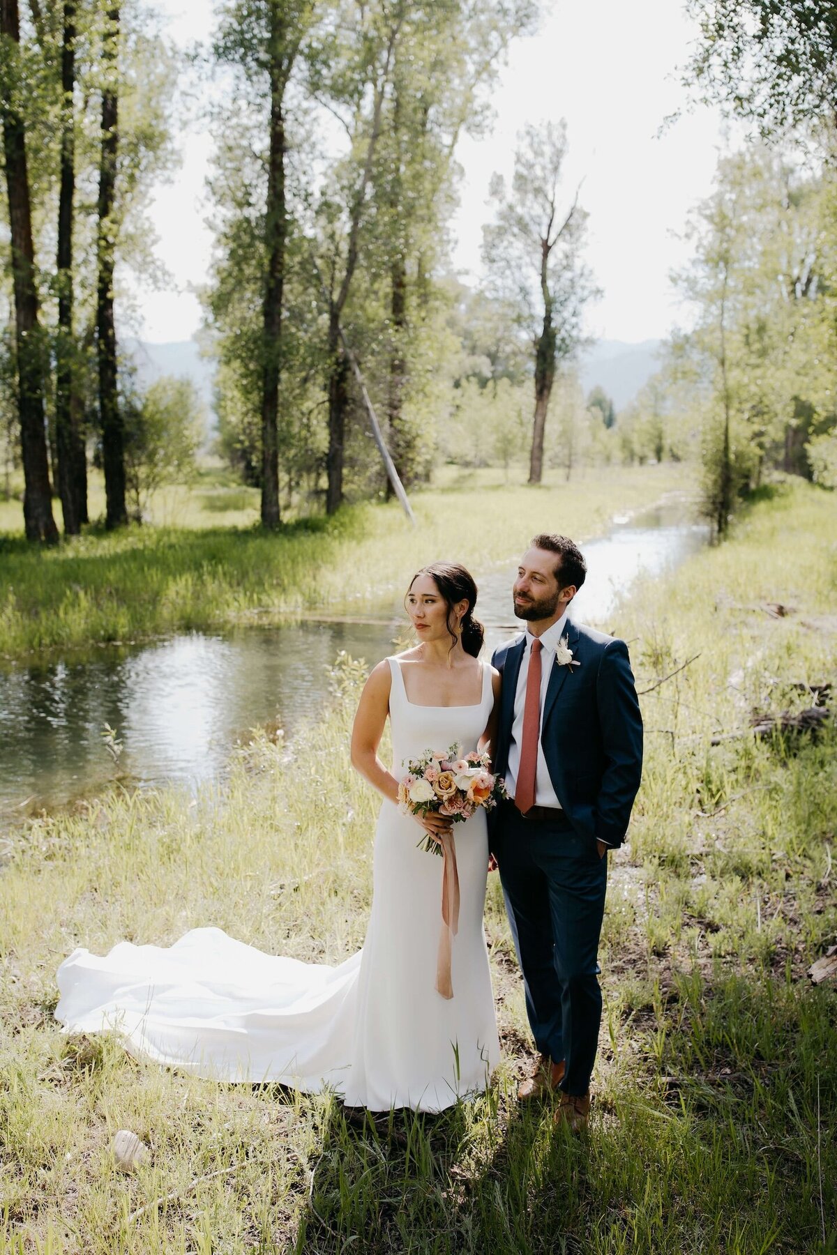 Bride-groom-by-stream-river-wyoming-wedding