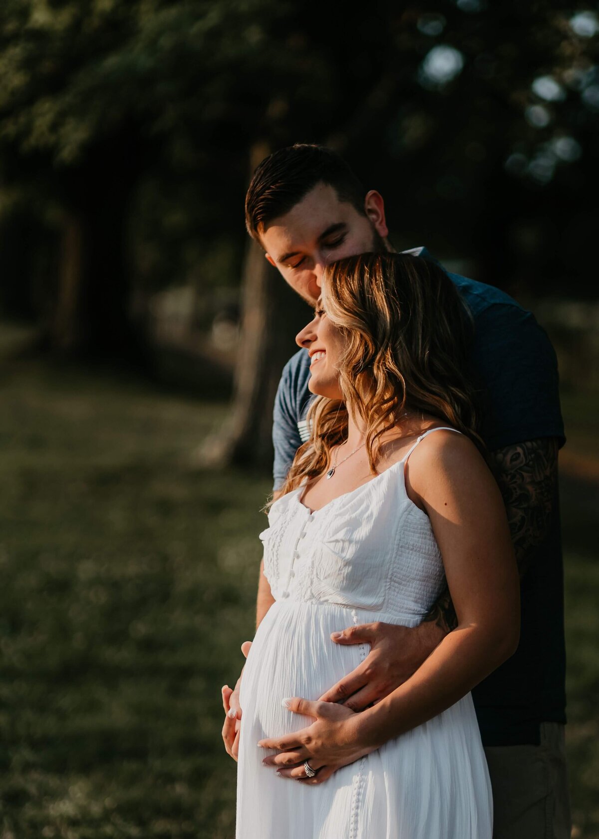 Pittsburgh maternity photographer captures a pregnant couple embracing in a field.