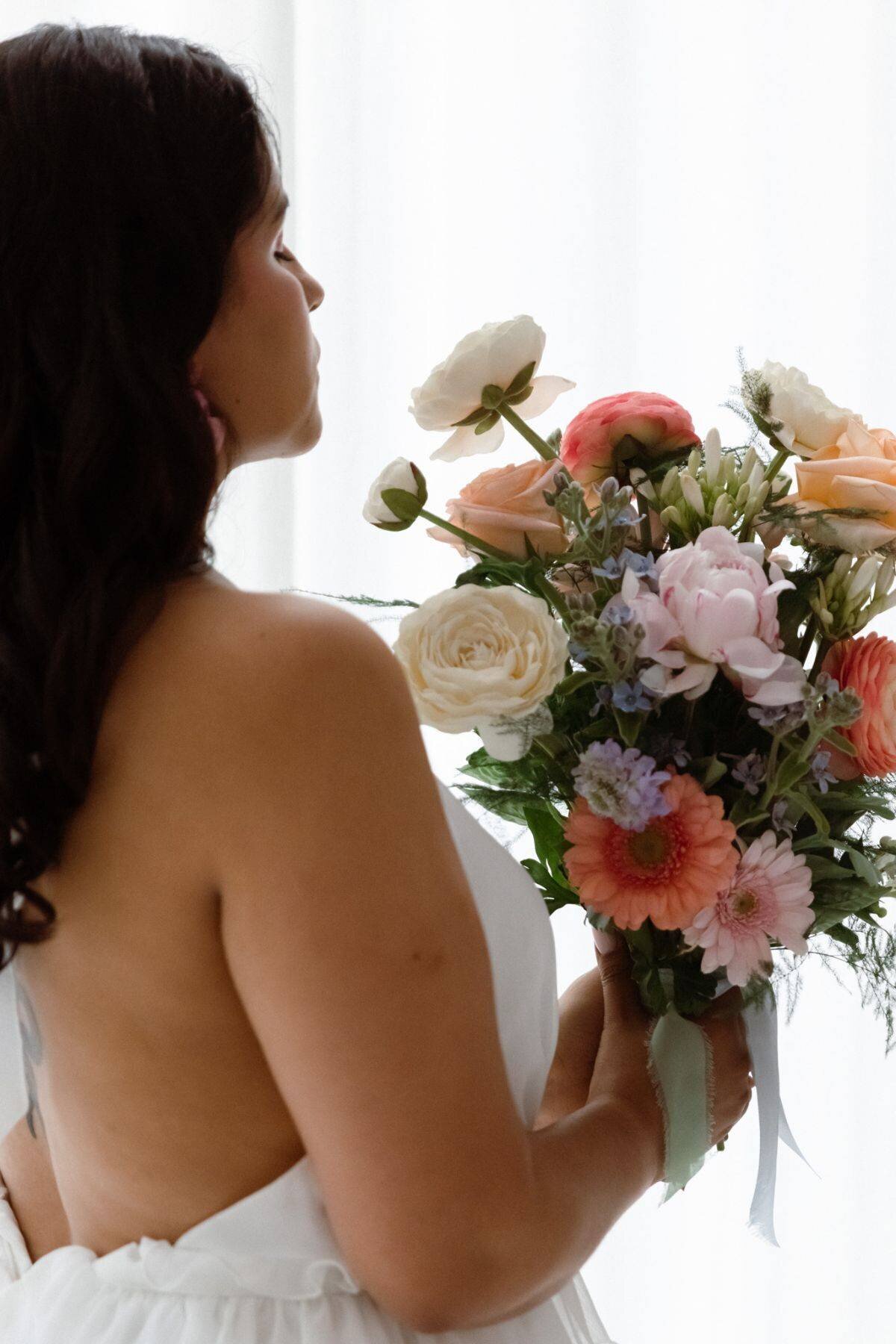 Portrait de la mariée avec son bouquet et sa robe de mariée à la fin des préparatifs de mariage à Lyon