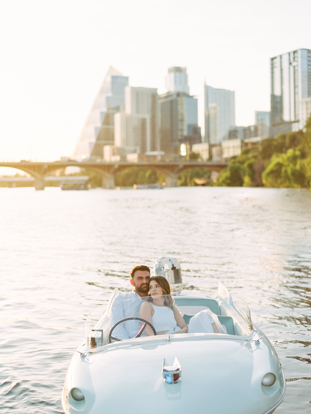 Couple in a boat with a city skyline in the background