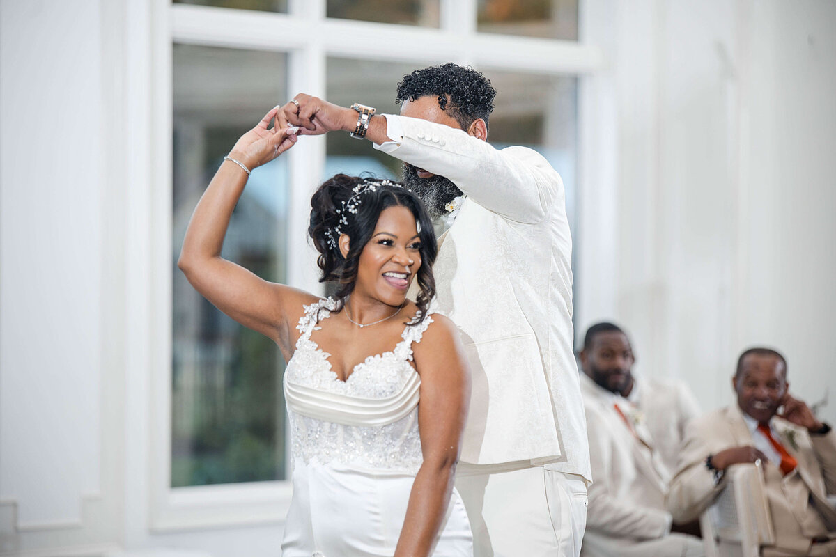 The bride playfully throws her bouquet while guests eagerly watch.