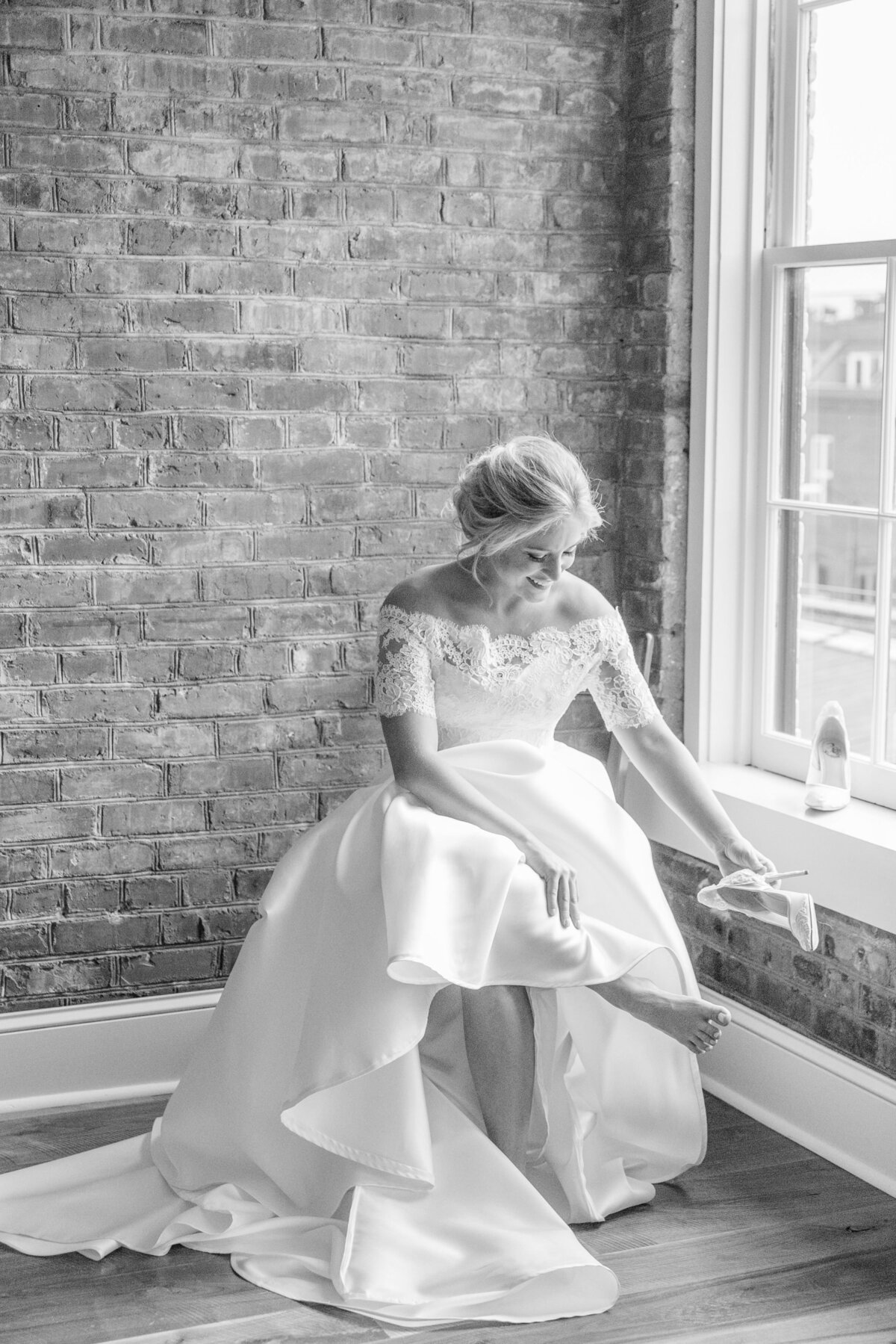 bride puts on her shoes on her wedding day