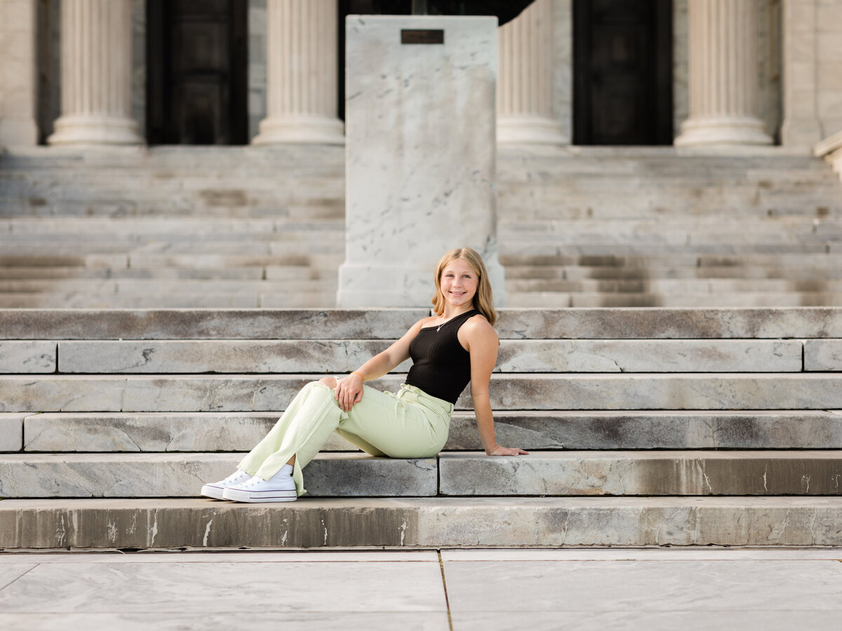 senior girl sitting on steps at cleveland art museum for senior portraits