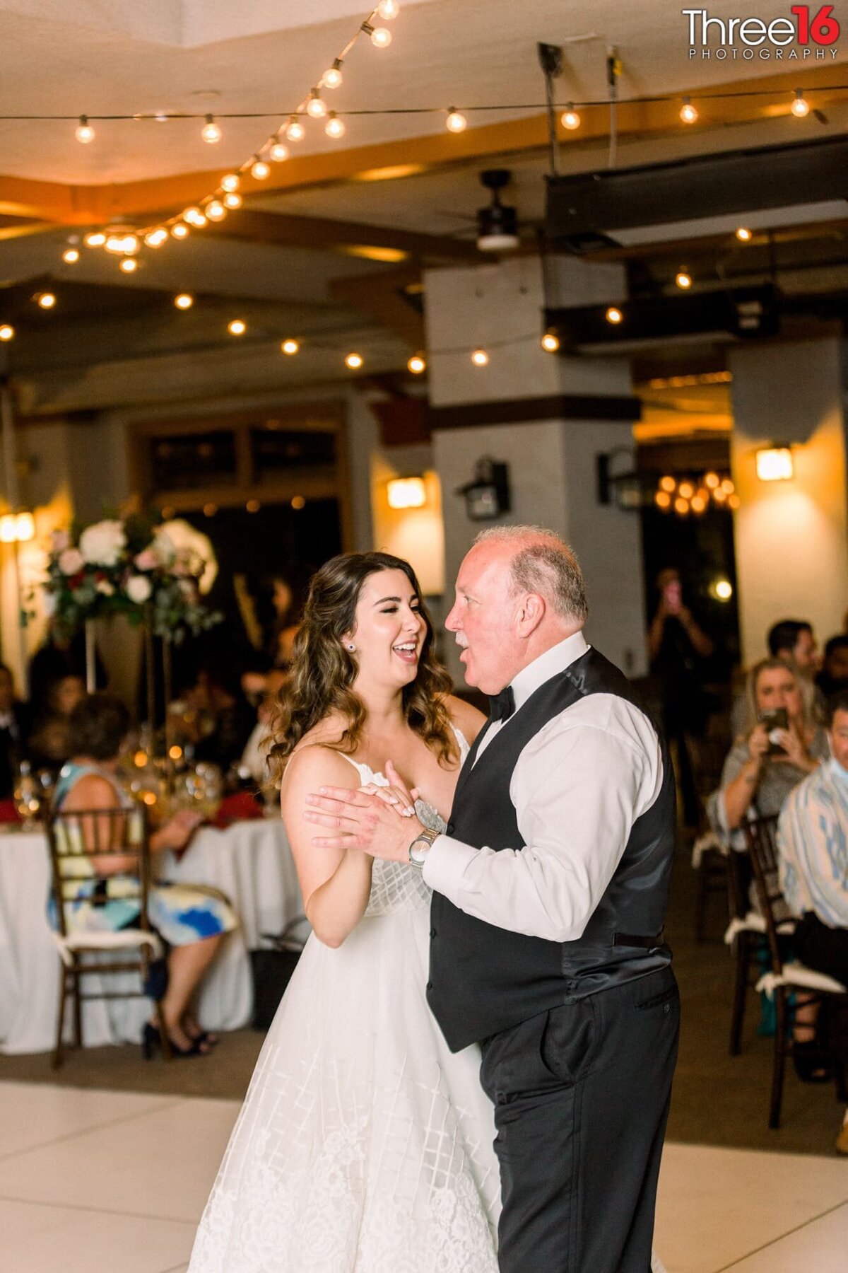 Bride dances with her father on the dance floor during her wedding reception