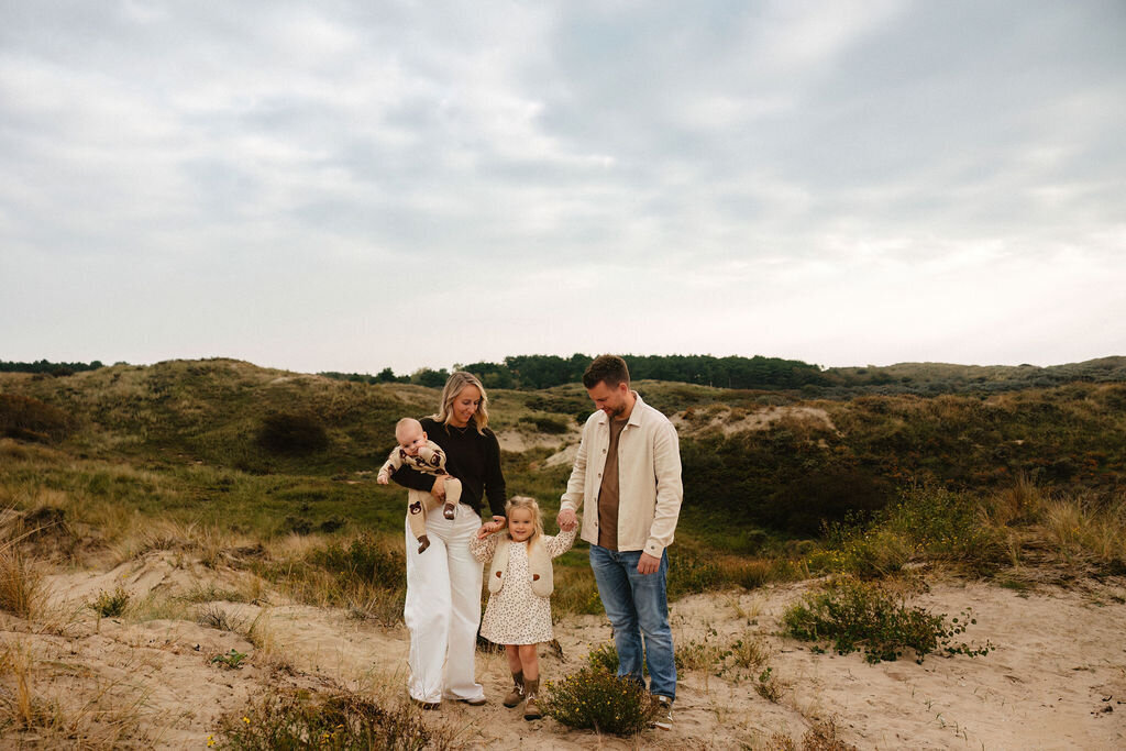 Gezinsfotoshoot in de duinen van Wassenaar met ouders en twee jonge kinderen in warm, natuurlijk licht door Linda Photography