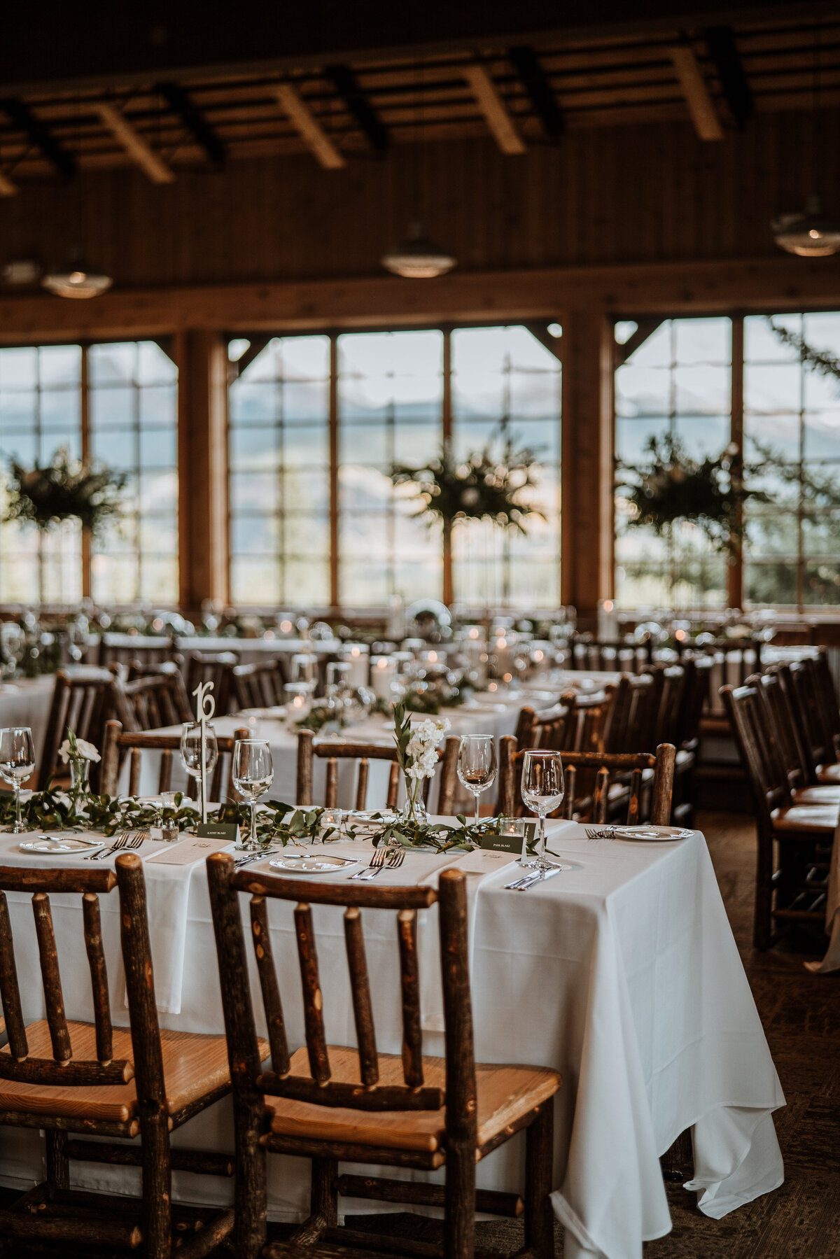 Elegant wedding reception setup at Ten Mile Station with rustic chairs and greenery by Breckenridge wedding photographers.