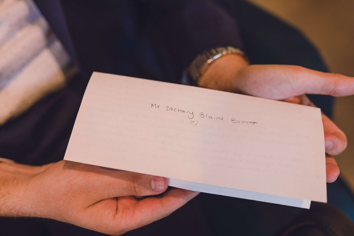 groom holds letter to him from bride