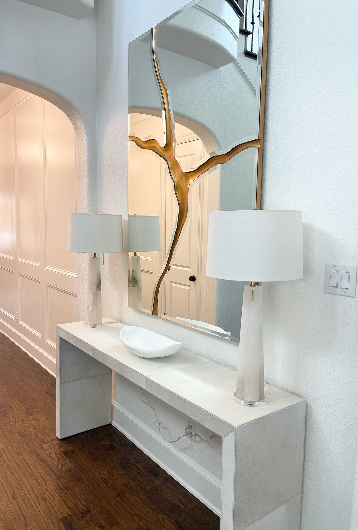 Home interior project management for a house hall table project, featuring a stylish table decorated with elegant white lamps, creating a sophisticated and welcoming atmosphere.