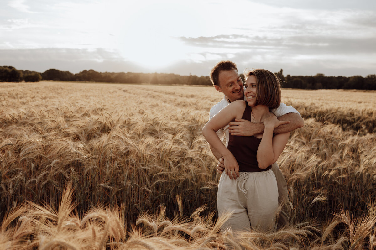 Koppel omhelst elkaar in graanveld tijdens koppelshoot