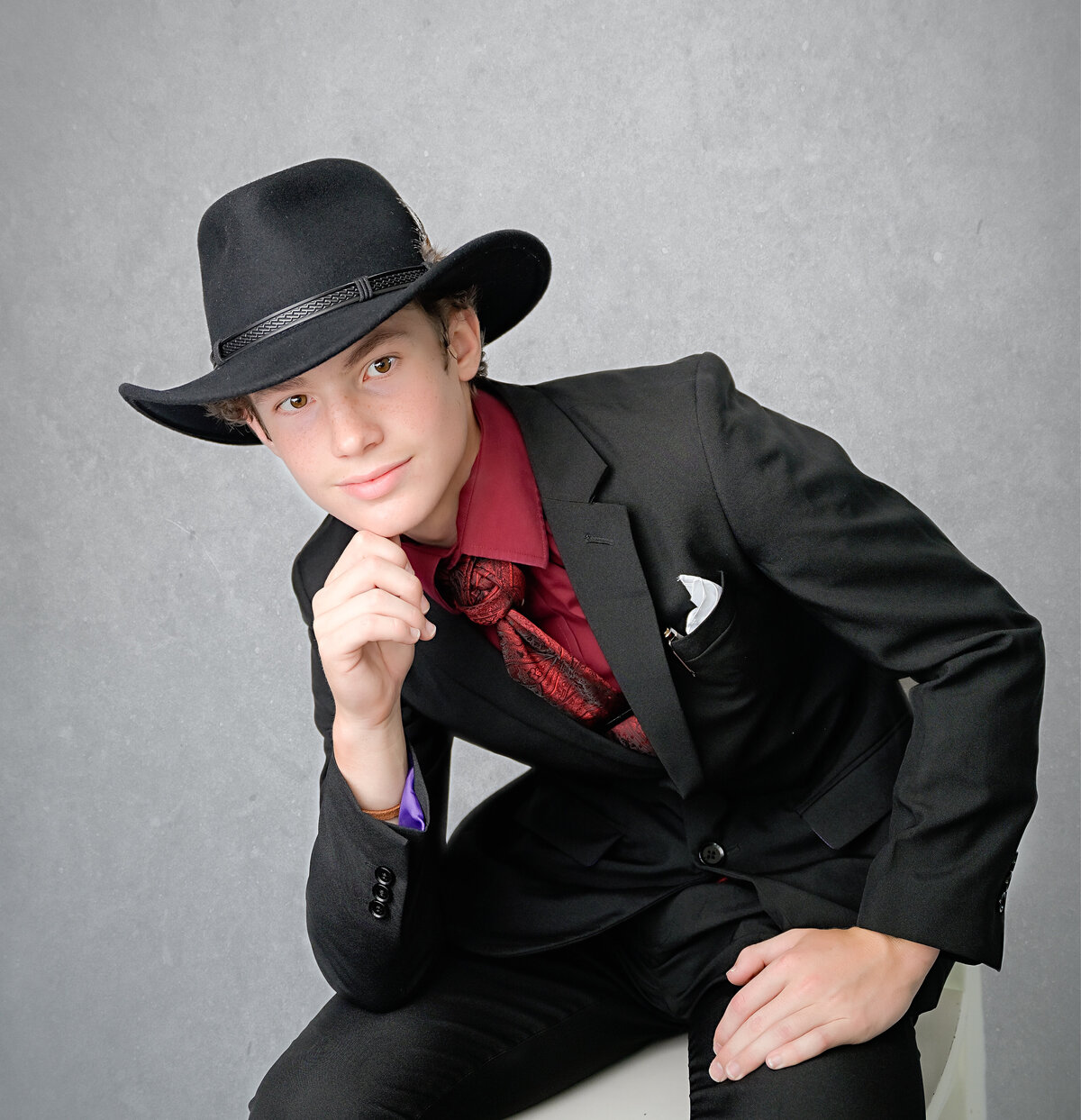 McKinney, TX teen poses with a thoughtful expression for his family photo session in his home in McKinney, TX