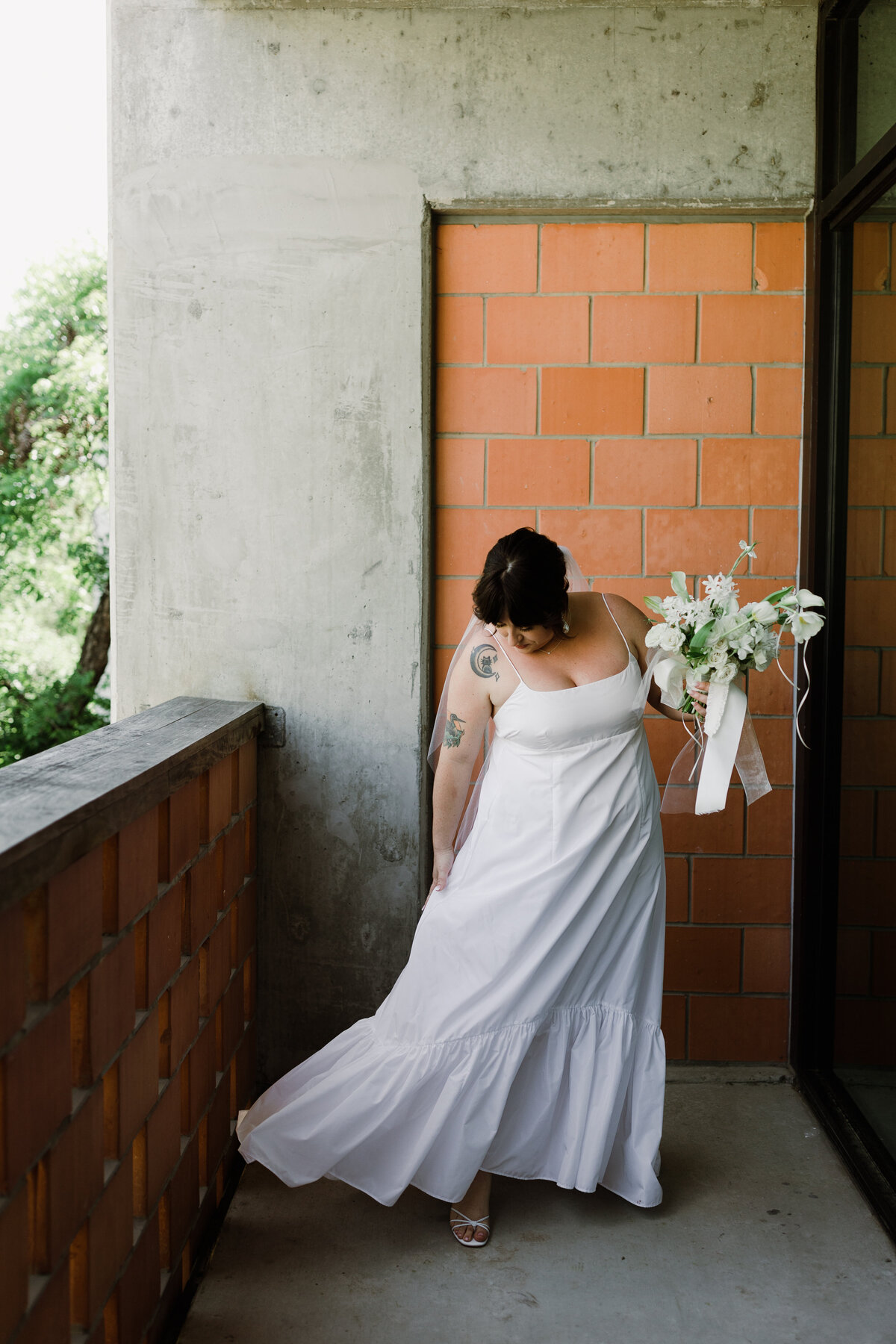 Bride wearing white gown holding bouquet of white florals
