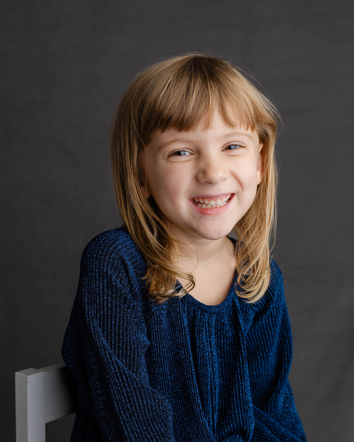 Cute smiling blonder preschool girl poses and smiles for her school picture with las vegas photographer, jessica Bowles
