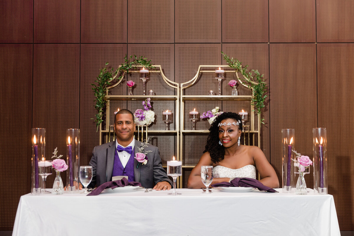 bride and groom sitting at reception table