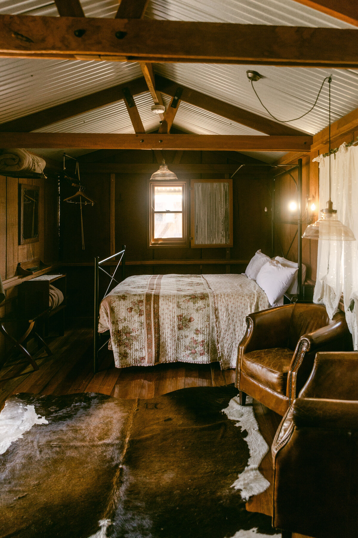 Rustic airbnb photographer and branding expert Chelsea Loren cowhide and dark woden beams with vintage accents