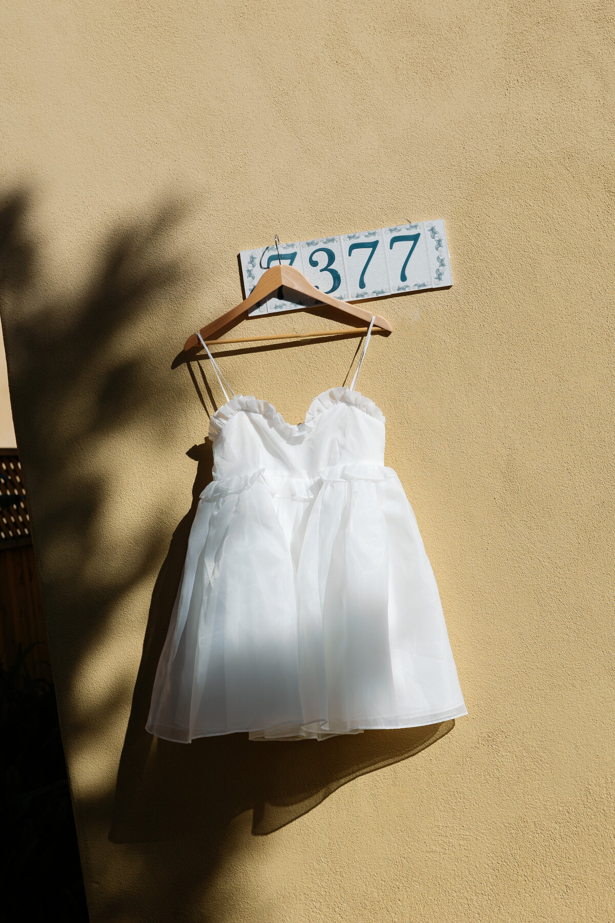 Wedding dress elegantly hanging against the backdrop of a beautiful villa in La Jolla, highlighting the romantic setting.