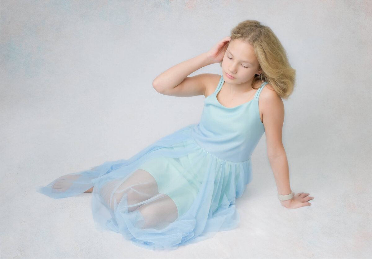 Young girl plays with her hair during this studio-like in home family photo session.