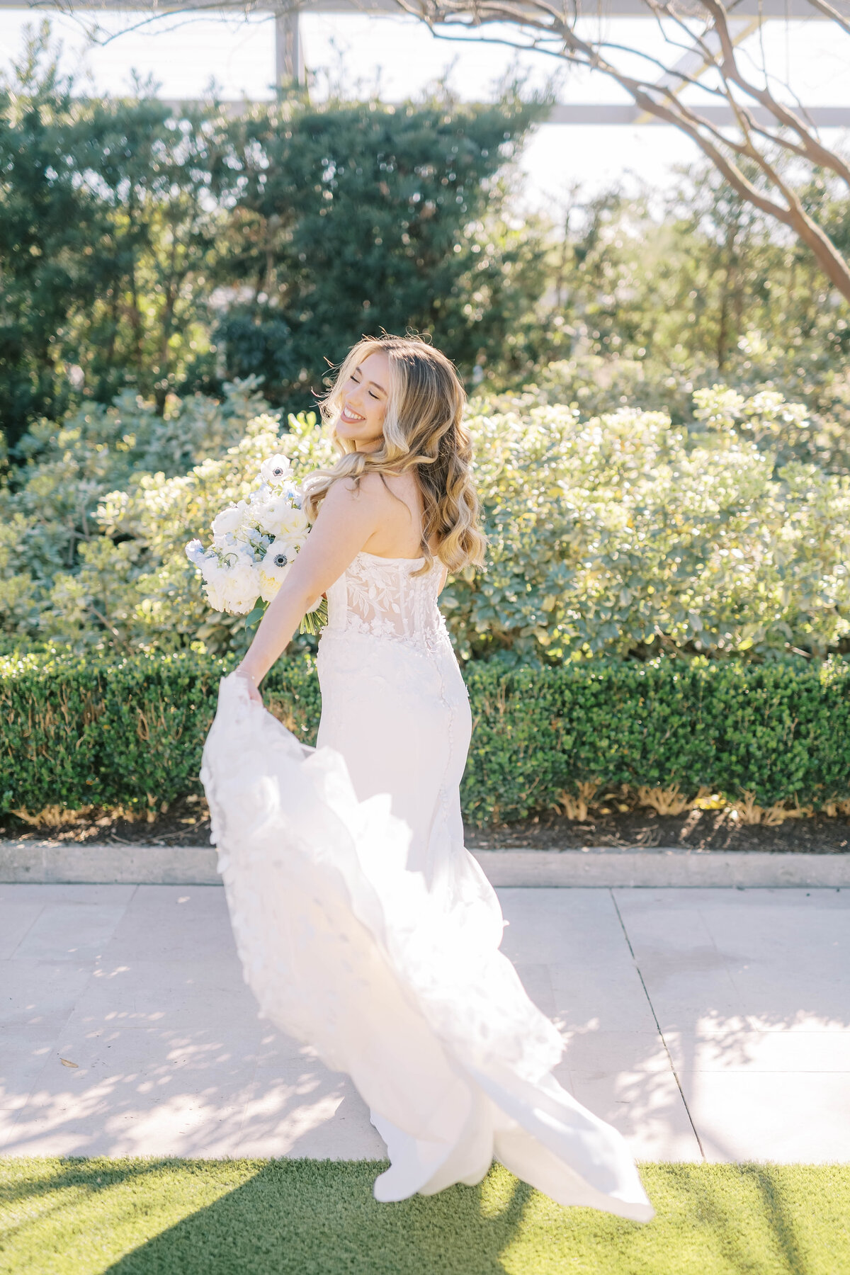 Bride walking while twirling the train of her dress