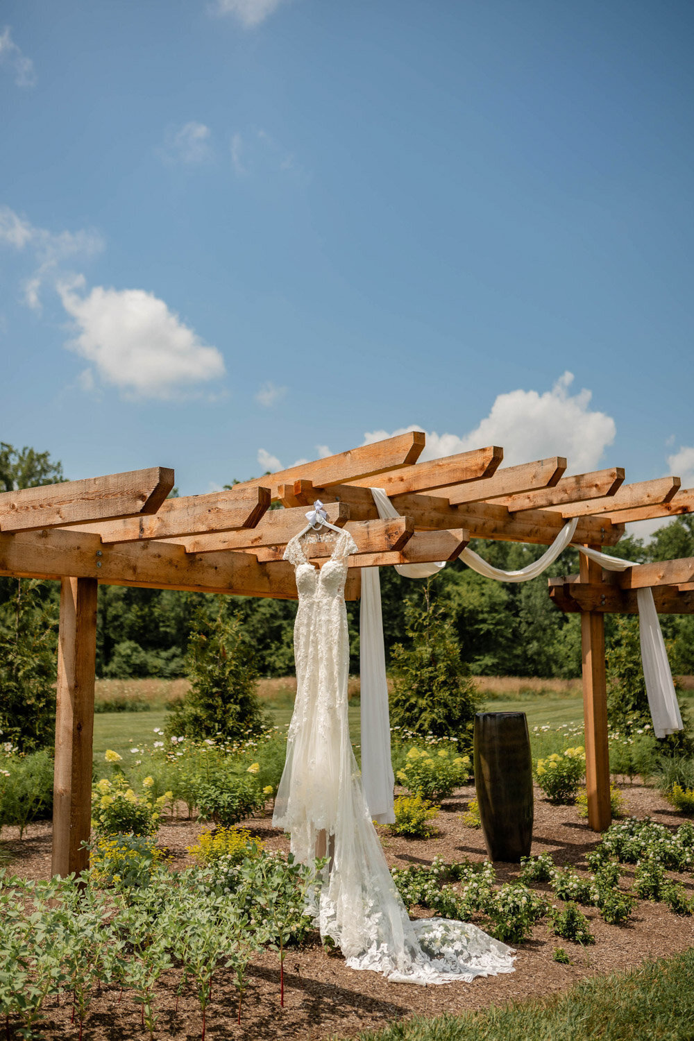 Brides wedding dress hanging in the pergola