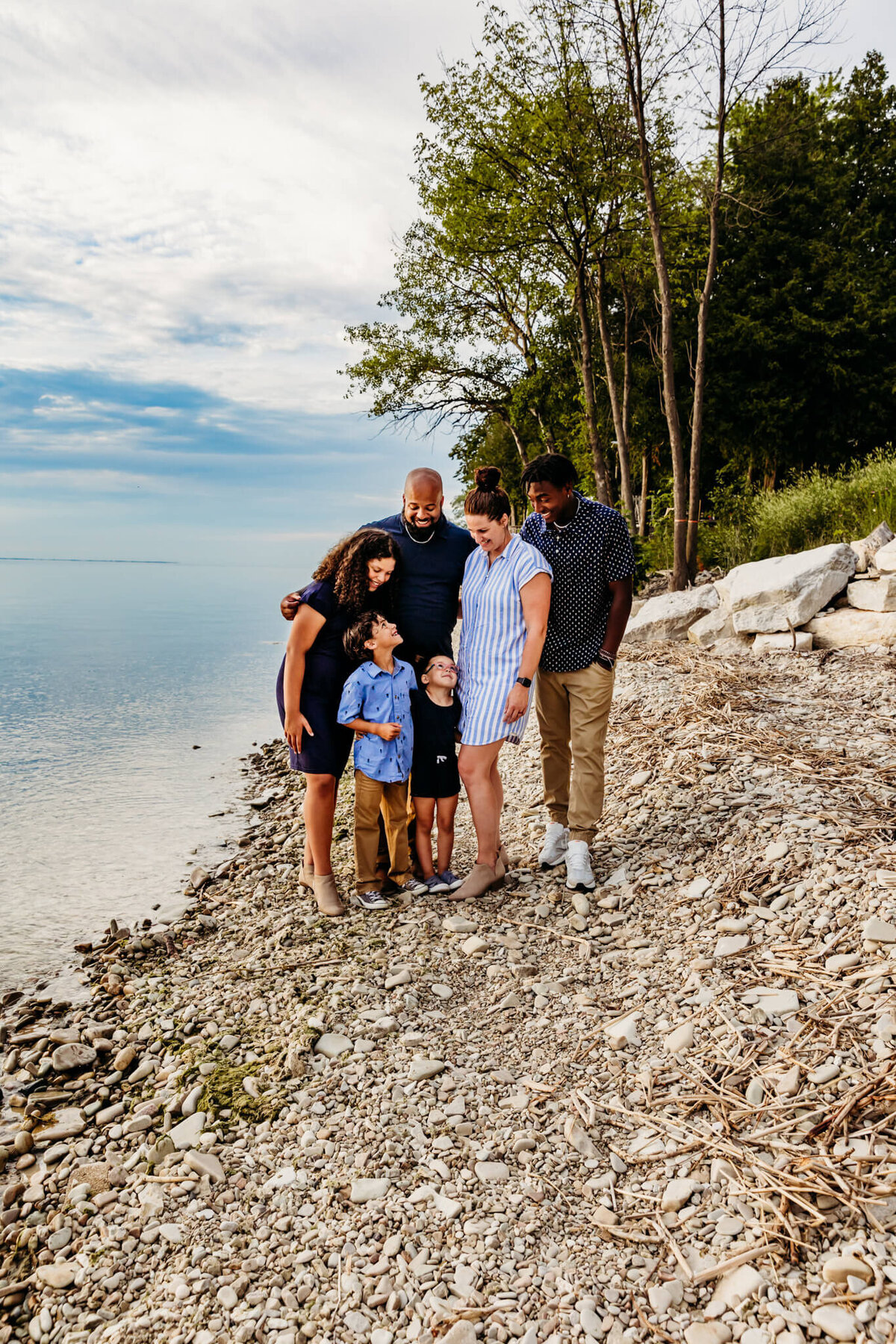 beautiful family laughing together on a rocky beach for photo session