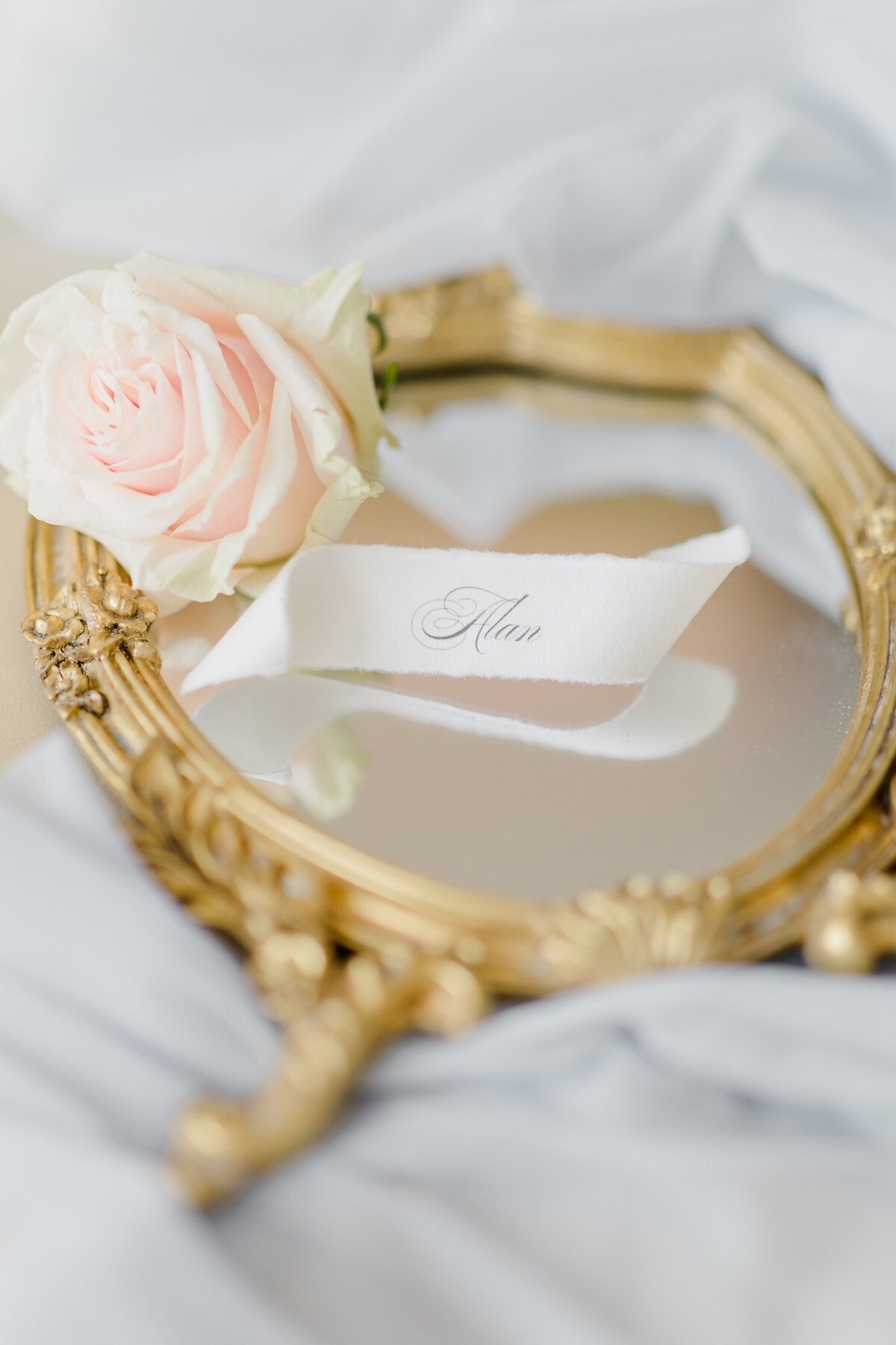 Details of a mirror with a fresh rose in blush at the destination wedding in Tuscany