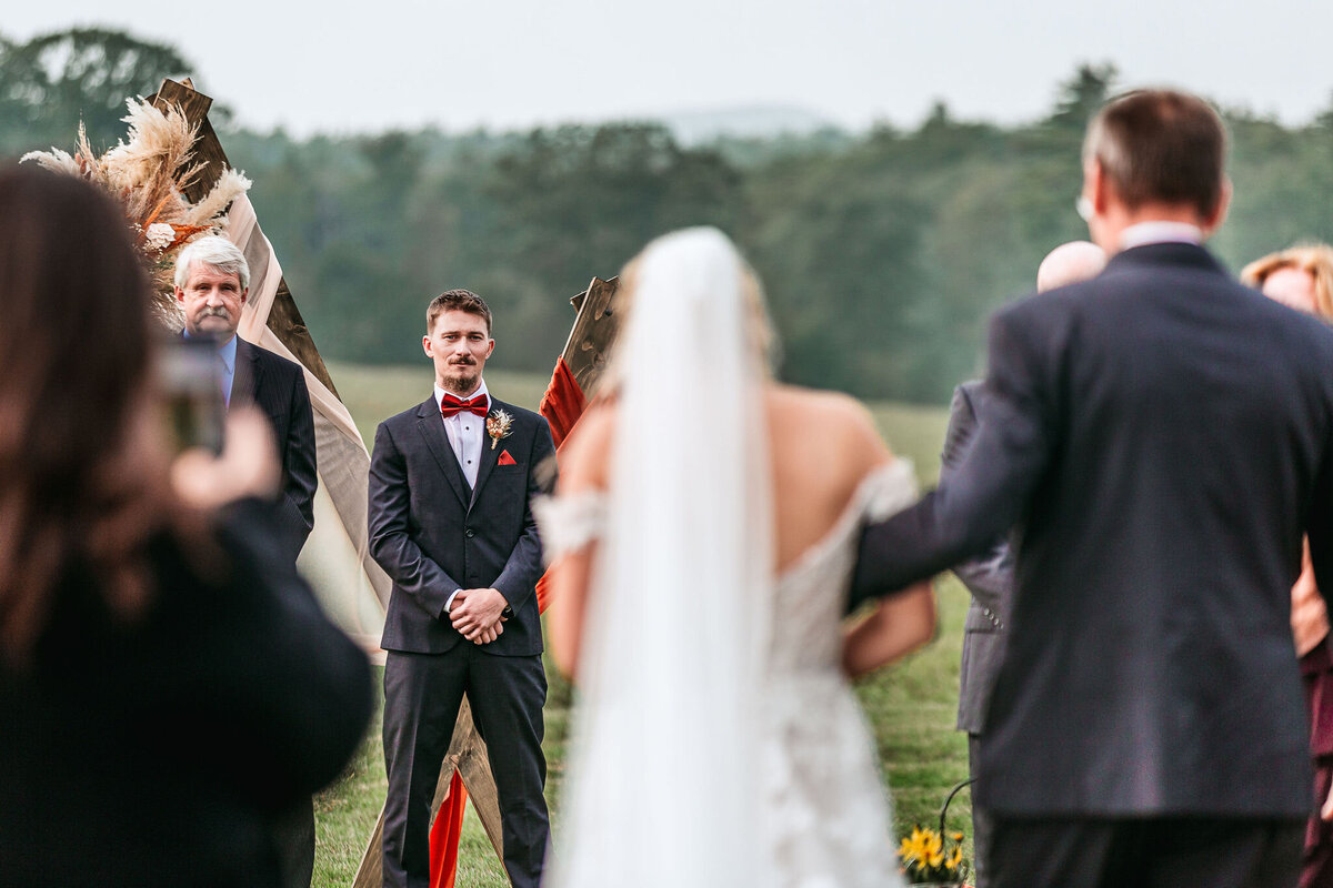 Groom seeing bride for the first time as father walks her down the aisle at Sanborn Hill Farm  in New Hampshire by Lisa Smith Photgraphy