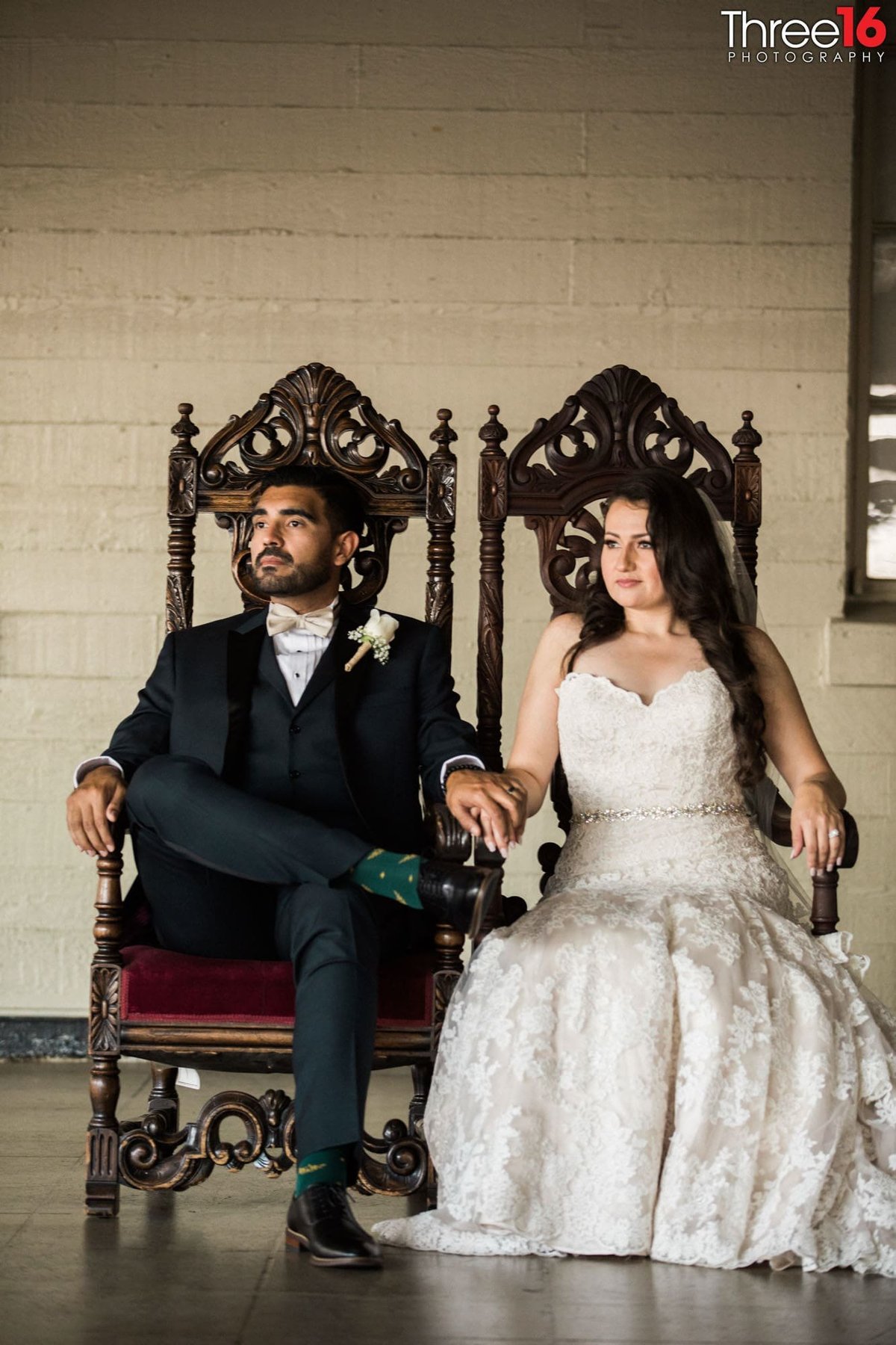Bride and Groom sit in formal chairs