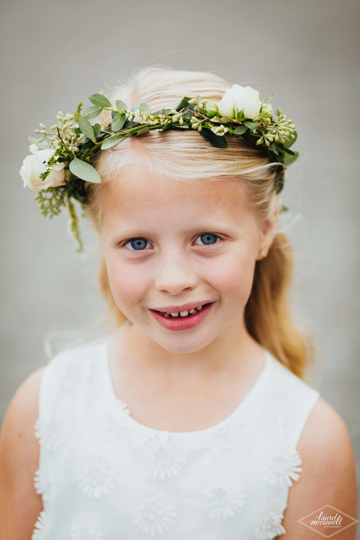flower girl with greenery crown and ivory spray roses