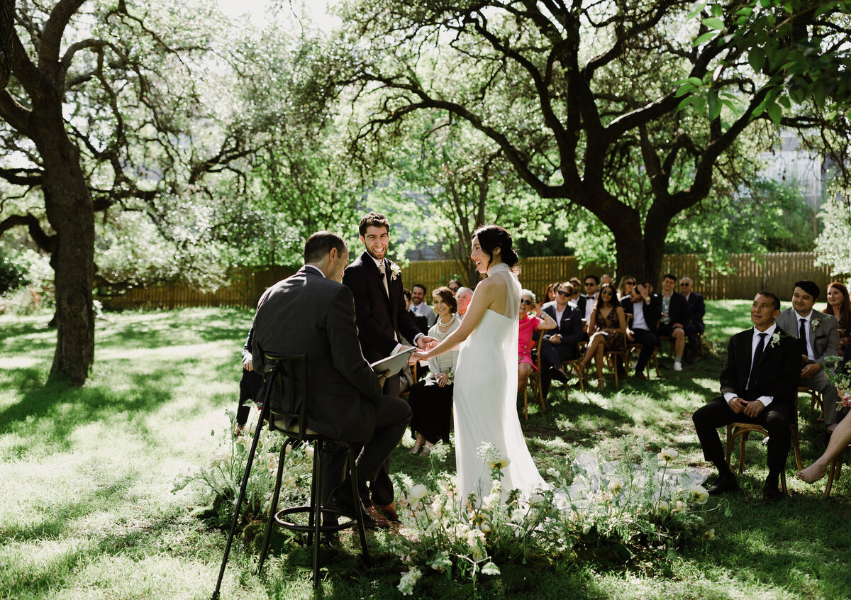 Bride and groom exchanging vows under a tree at  Mattie's Austin wedding