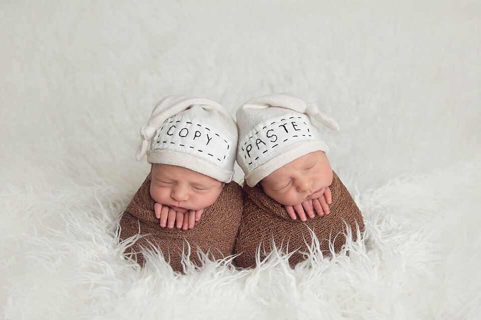Sleeping newborn baby twins lay wrapped in brown swaddles in a NJ Newborn Photography studio