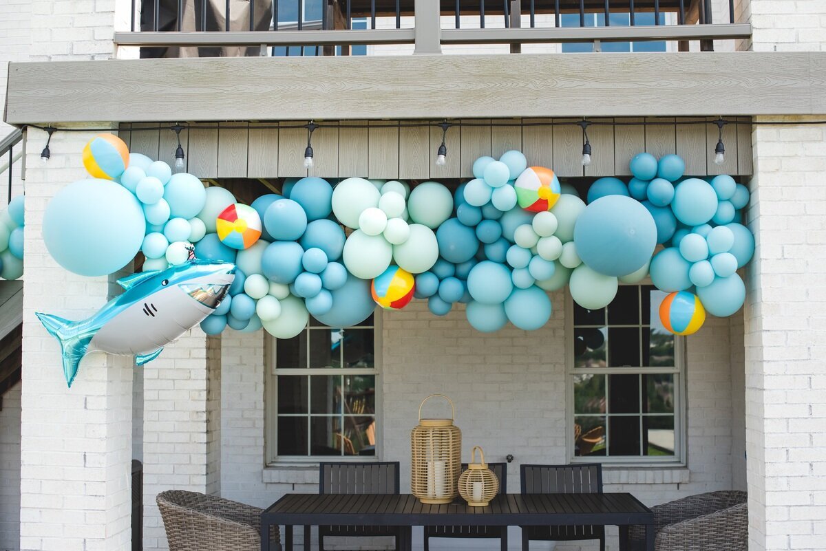Jaws shark themed balloon garland with beach balls and blue balloons