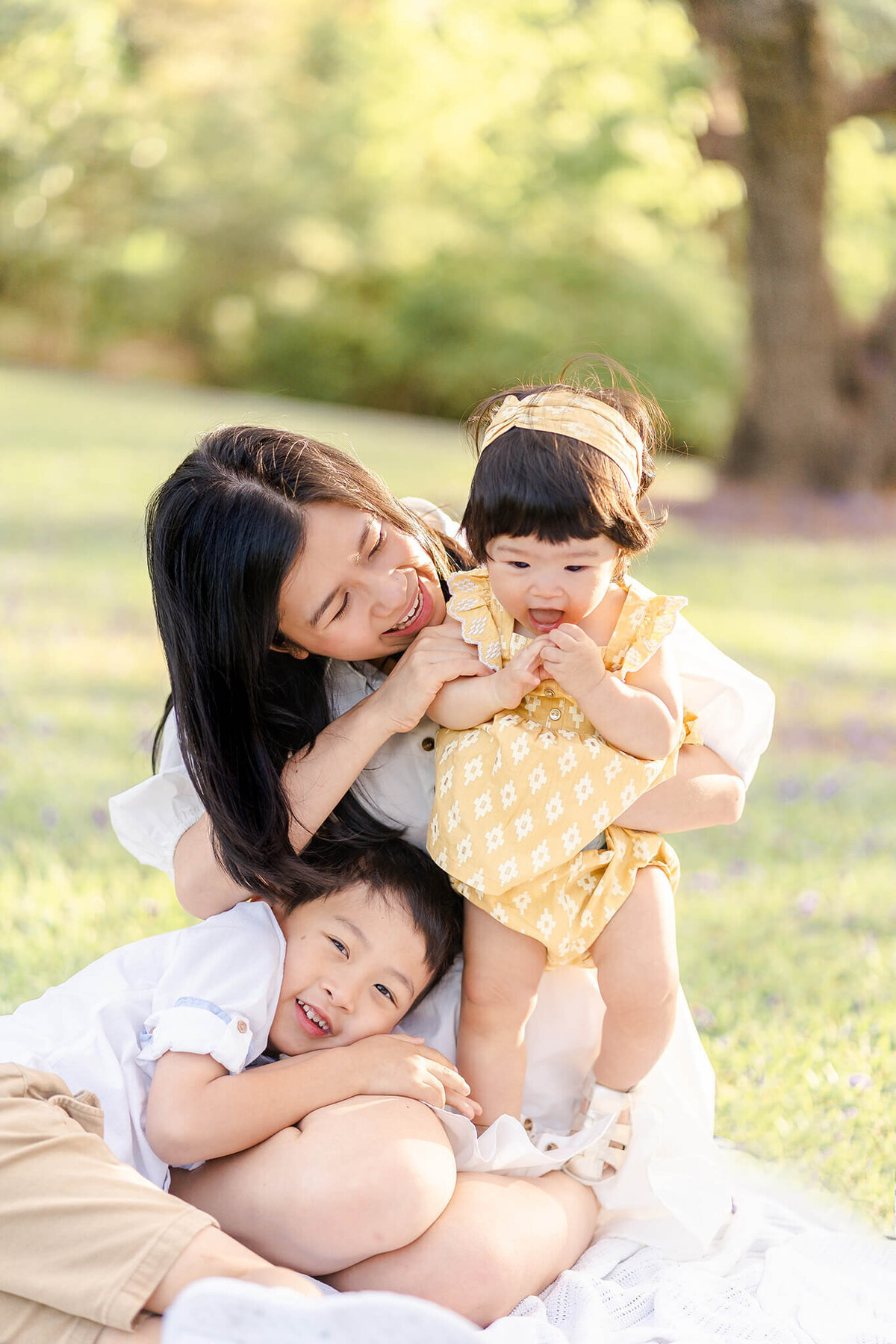mum cuddling up with kids in brisbane botanic gardens during family photography session with hikari