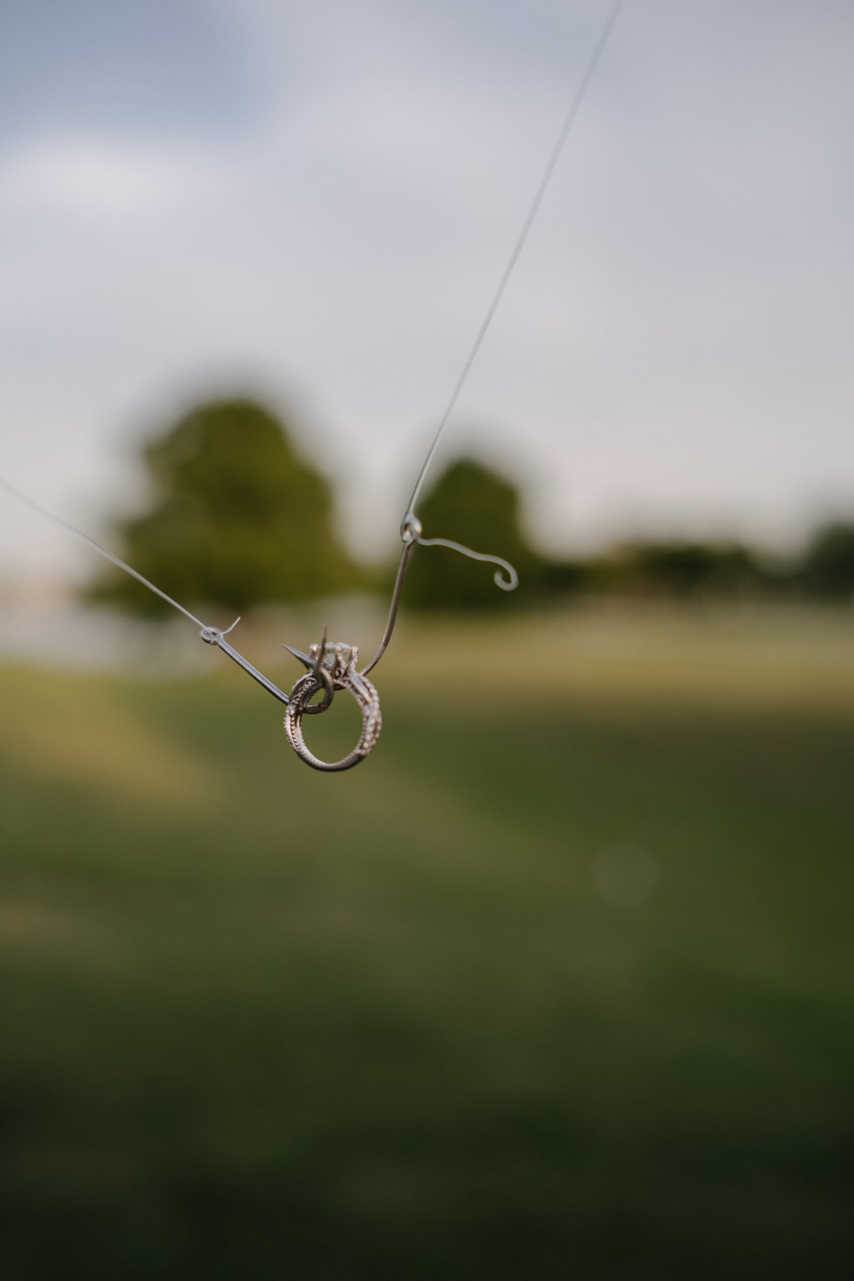 Picture of engagement rings on fishing hooks.