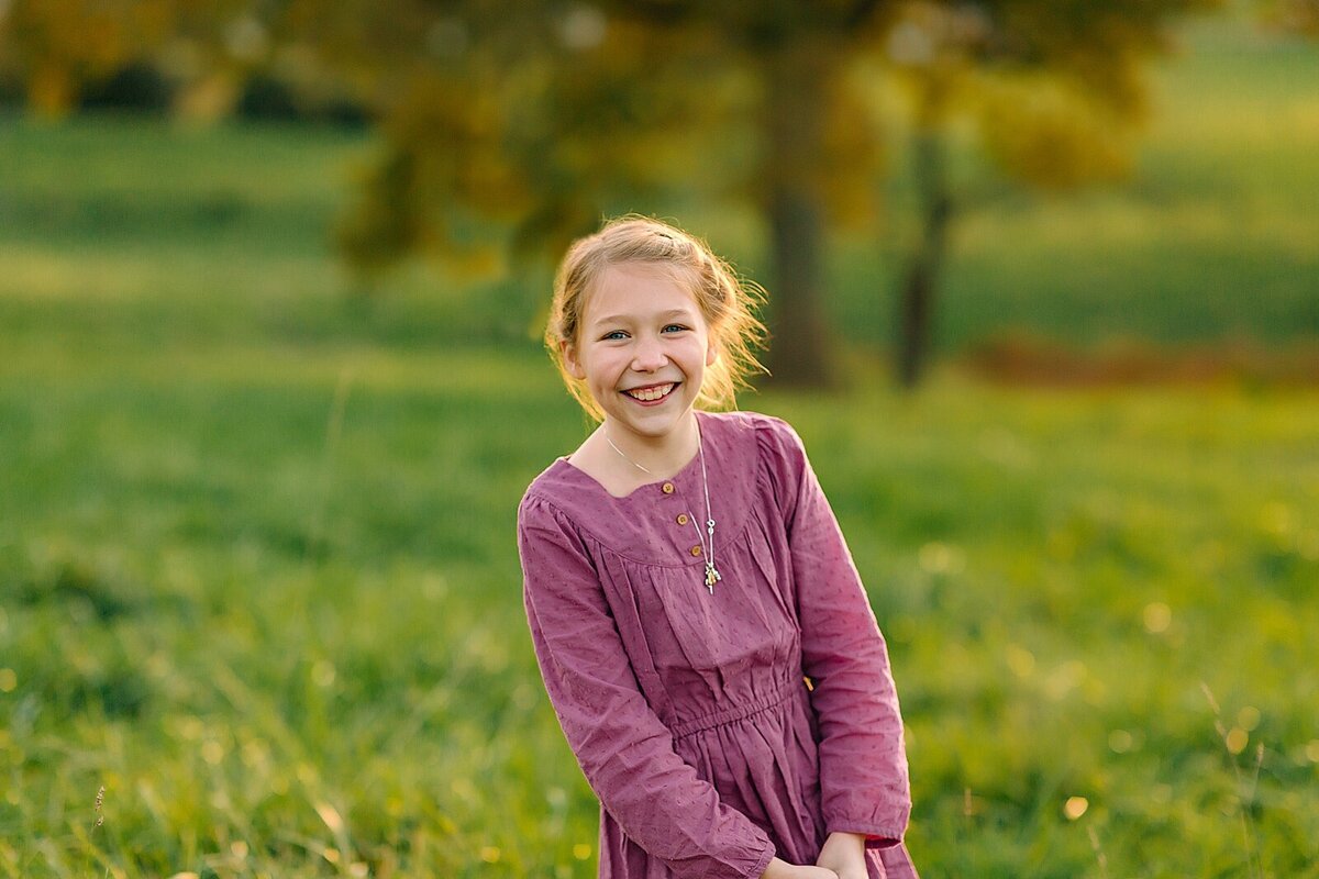 Girl wearing purple in a field during family pictures near Staunton VA