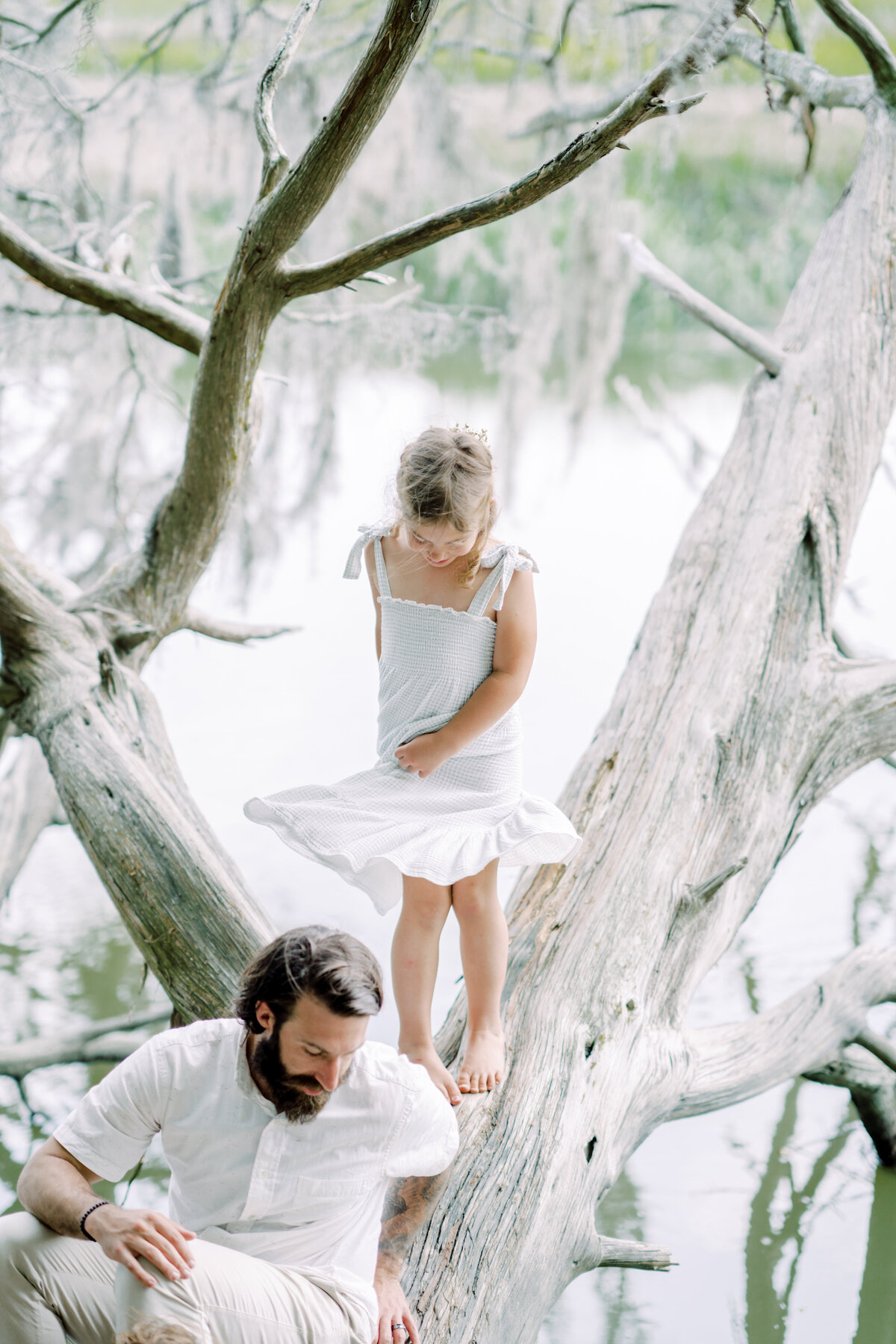 Little girls spins in her flowy dress while playing with her dad by Savannah Family Photographer Courtney Cronin