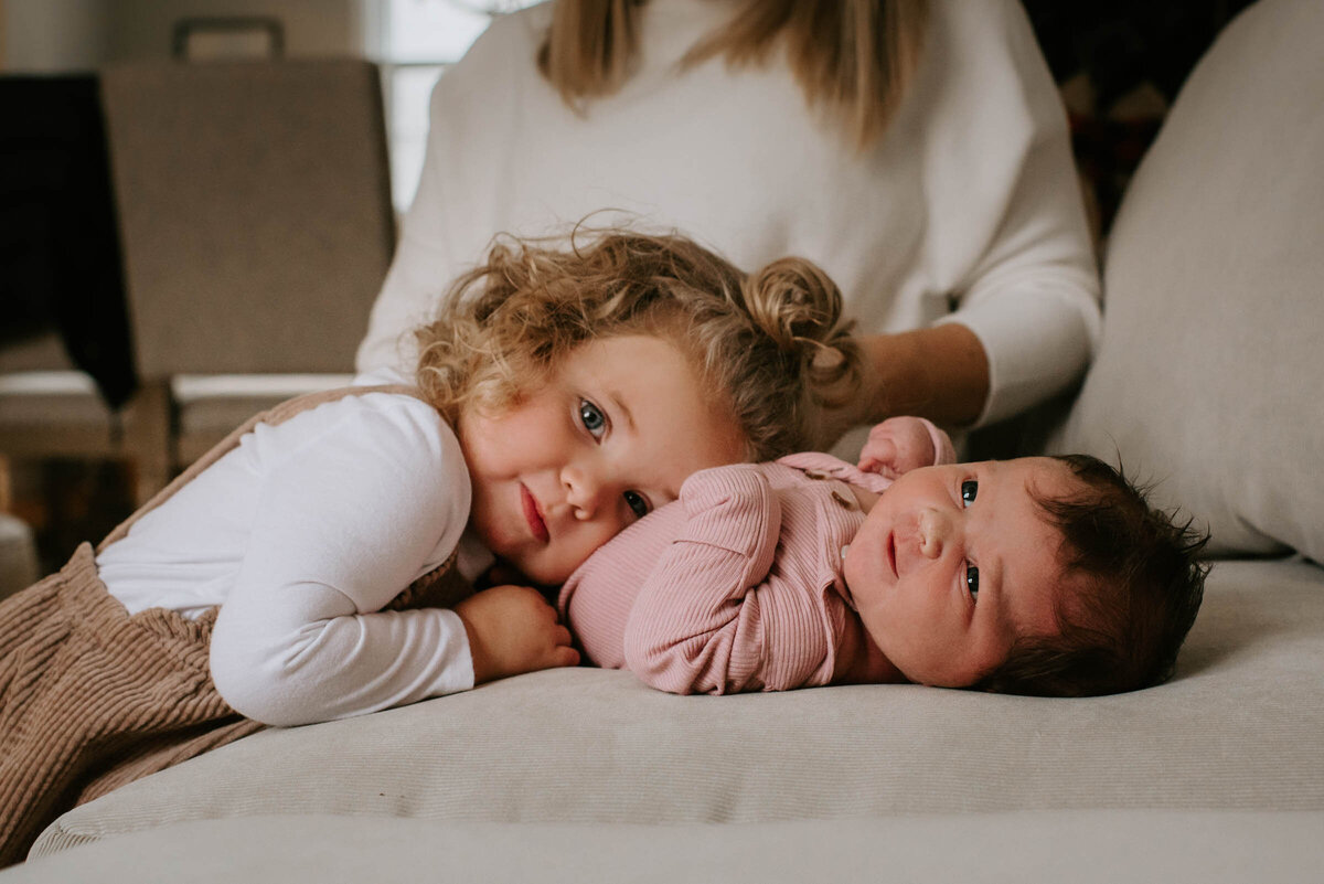 Siblings sister hugging newborn baby Newborn Portrait Photography Family