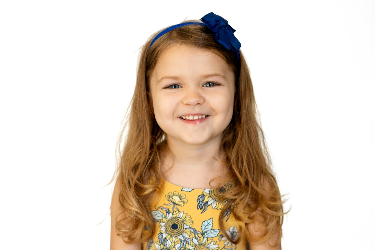Little girl with long hair smiling for fall school photo