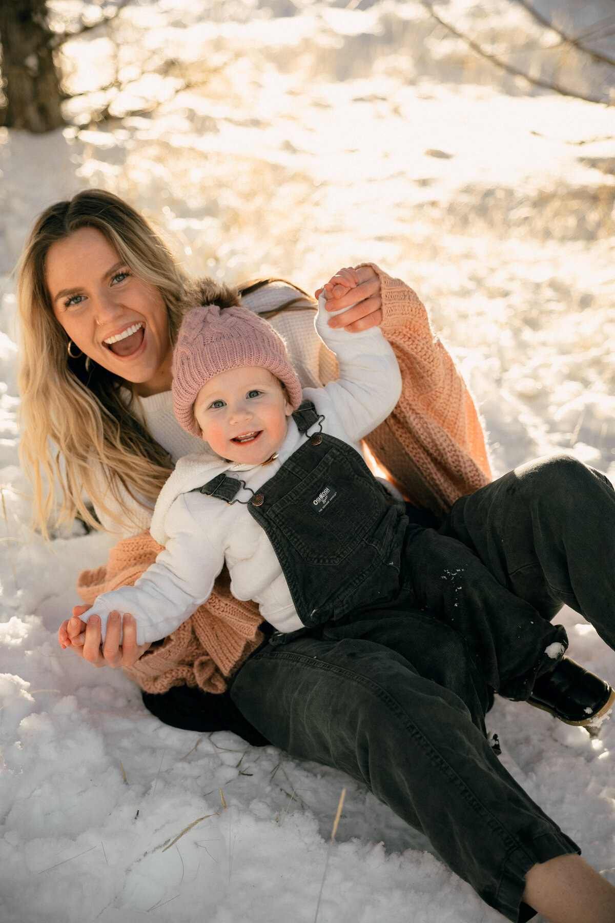 Joyful Mother and Toddler Laughing Together in the Snow During Winter Family Session