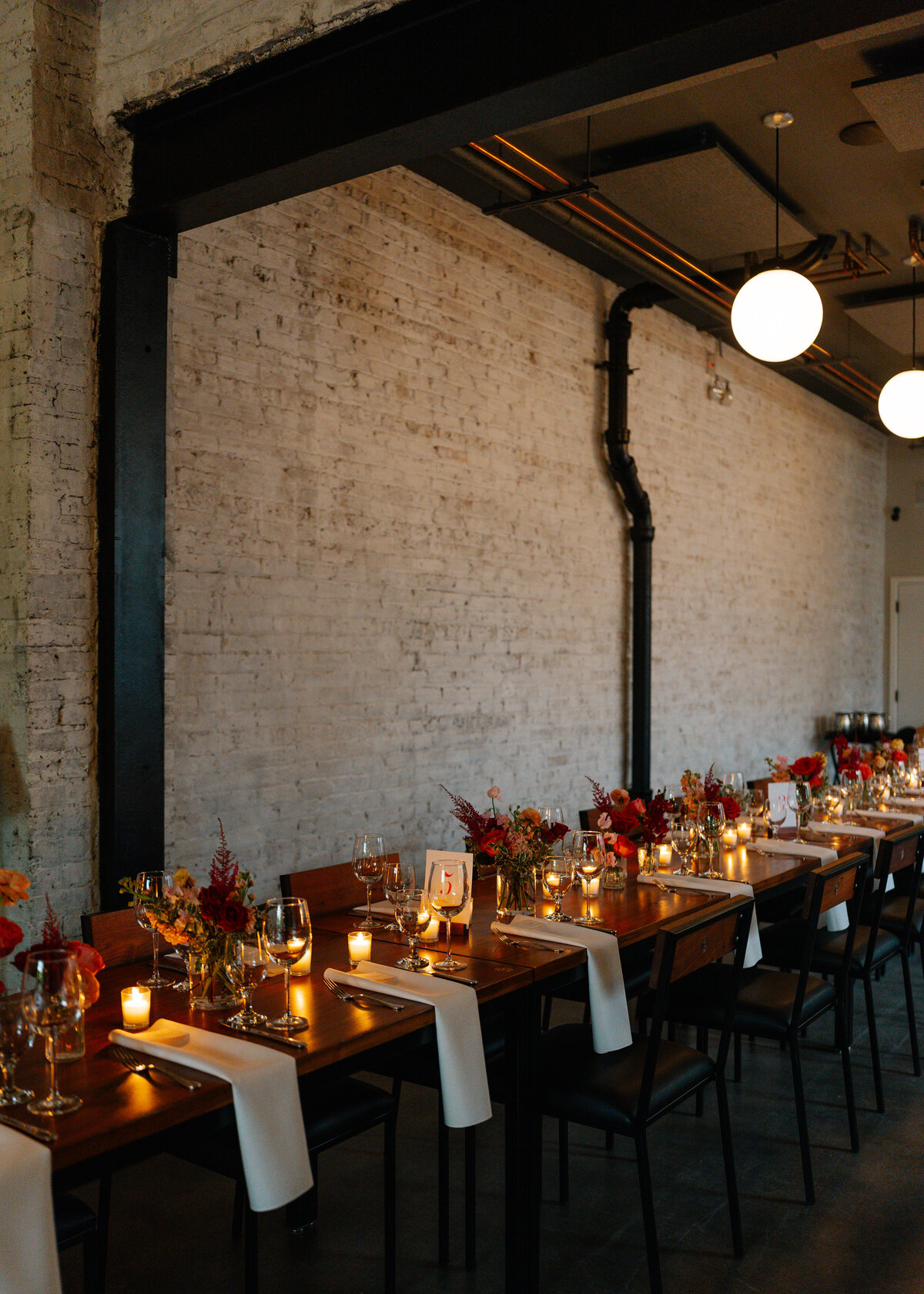 warm candlelight flowers long table wedding dinner