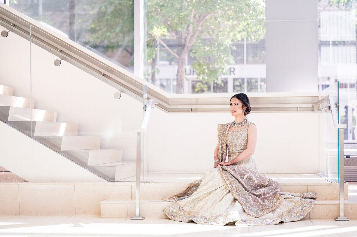 pakistani bride sitting on the stairs at the fairmont hotel pittsburgh with her dress on display