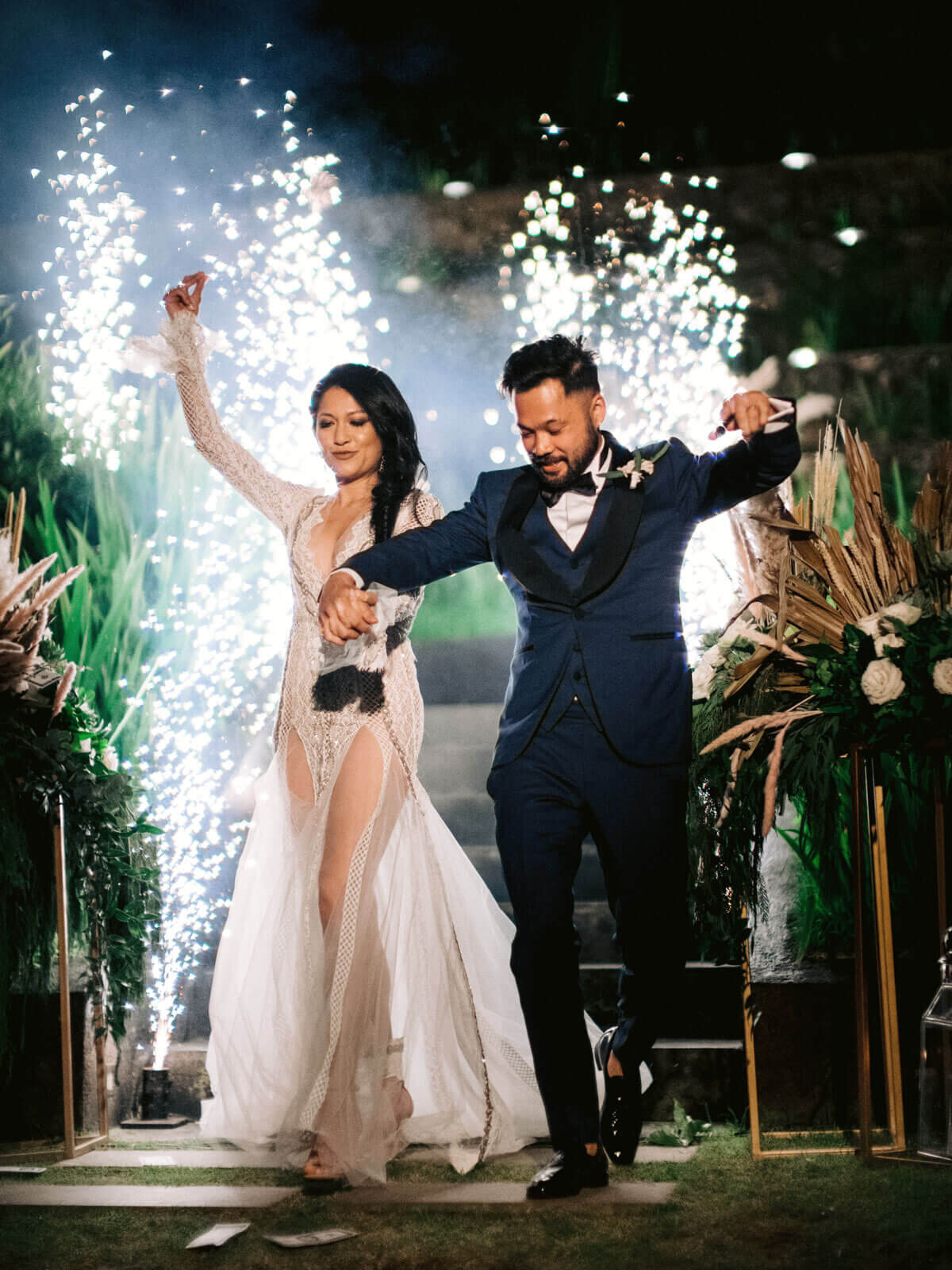 The newlyweds are dancing, with fireworks in the background, in Khayangan Estate, Bali, Indonesia. Image by Jenny Fu Studio