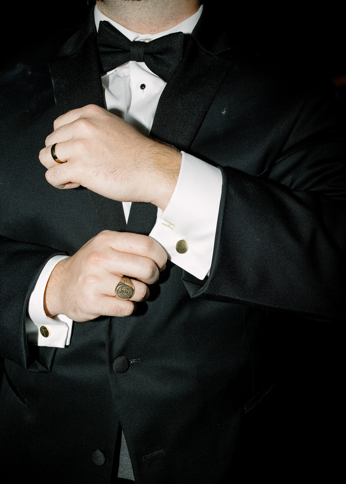 Flash photo of groom adjusting his wedding cufflinks
