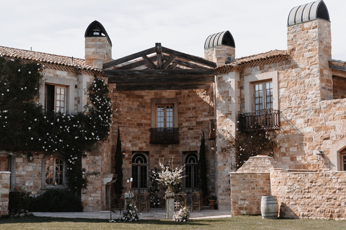 Stone facade of Sunstone Winery with floral accents and wedding ceremony decor in Santa Ynez, California.