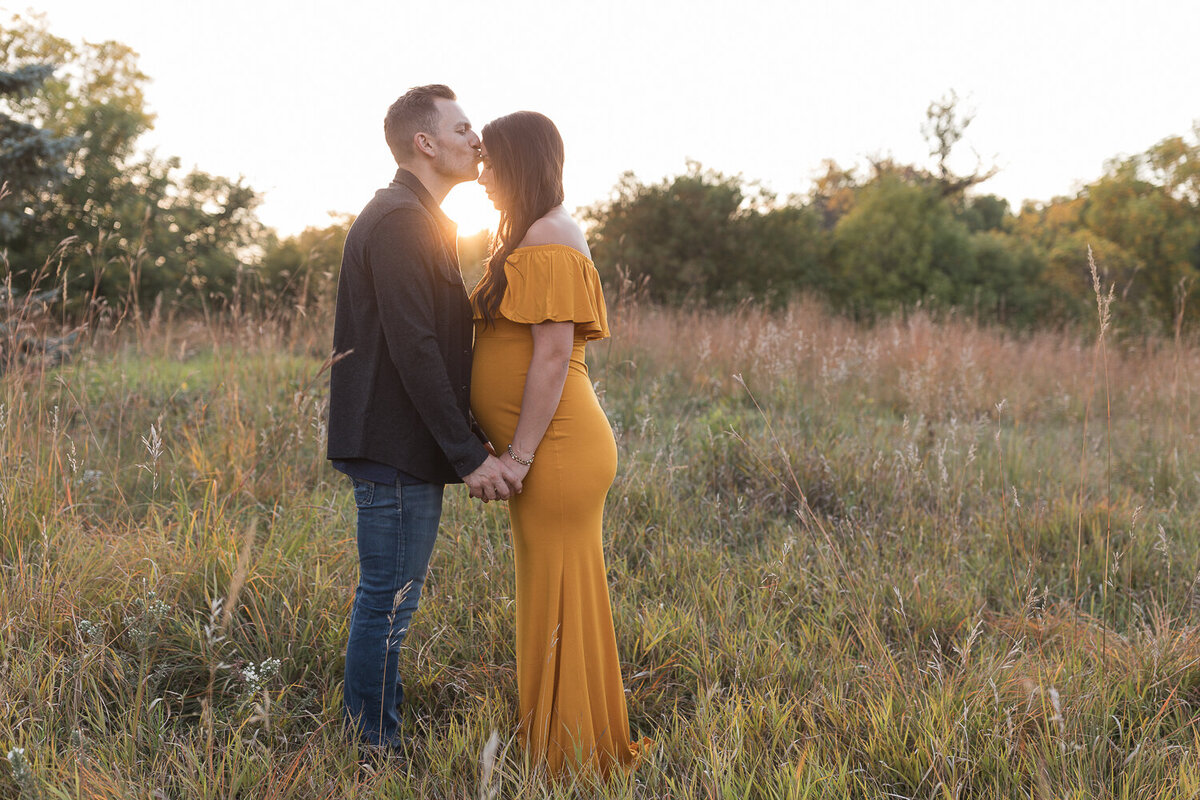dad kissing pregnant mom's head