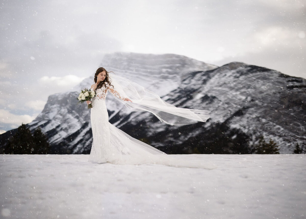 Stunning winter bridal portrait in the mountains captured by TkShotz, modern wedding photographer and videographer in Calgary, Alberta. Featured on the Bronte Bride Vendor Guide.