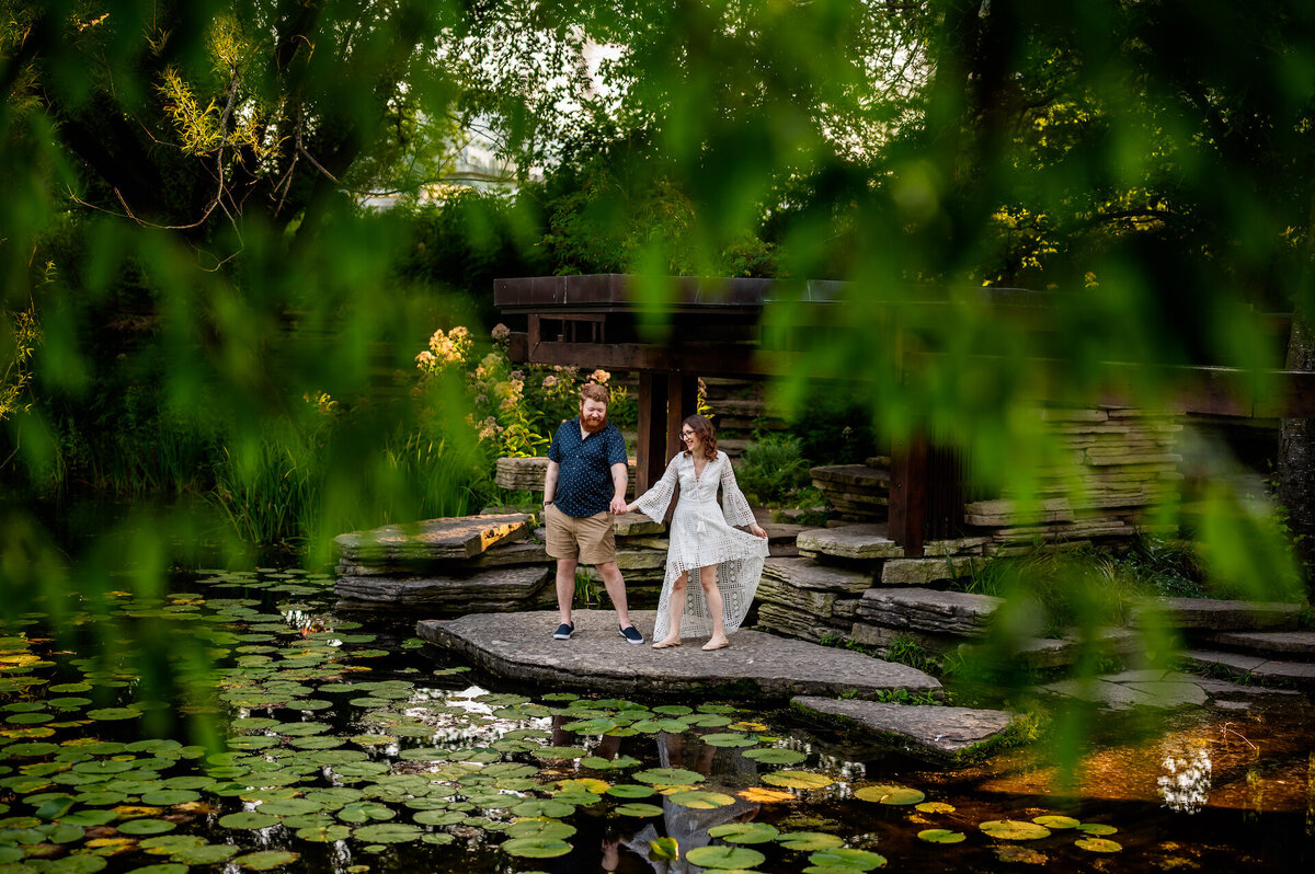A couple hold hands at Alfred Caldwell Lily Pool