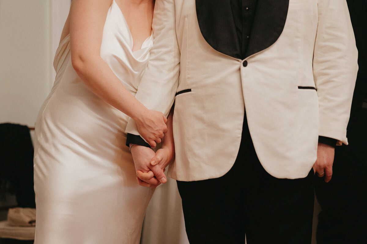 Close up of bride and grooms hands  holding each other